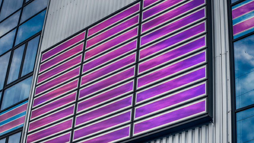 Building façade with purple solar panels Building façade with purple solar panels integrated into glass and metal cladding