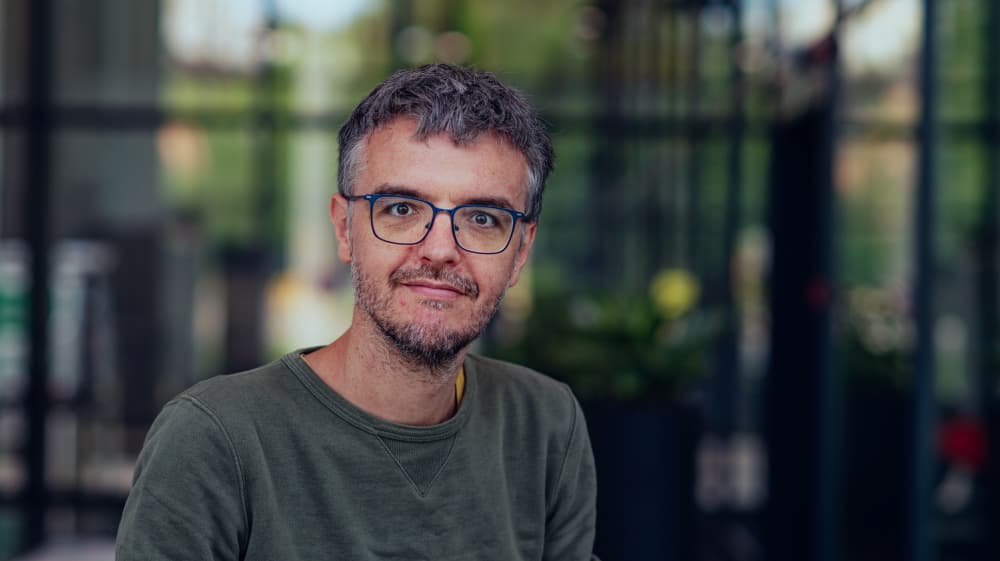 Pieter-Palmers Portrait of Pieter Palmers wearing glasses against a blurred indoor background