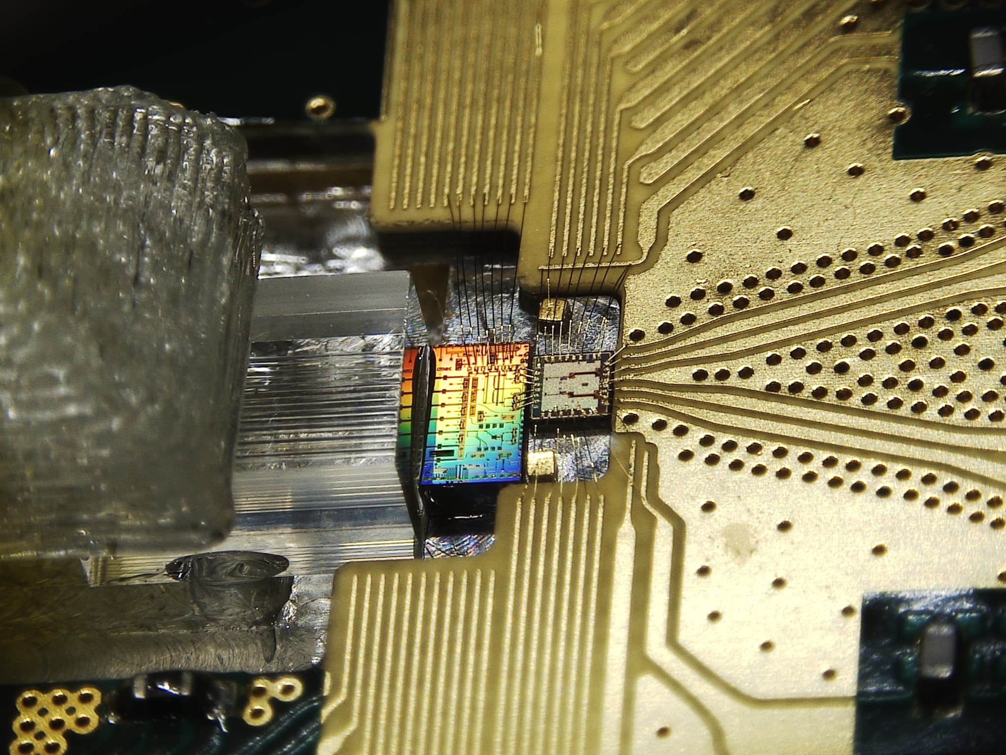 QKD_receiver_chip Quantum receiver chip with gold wire bonds and a rainbow-colored die on a circuit board