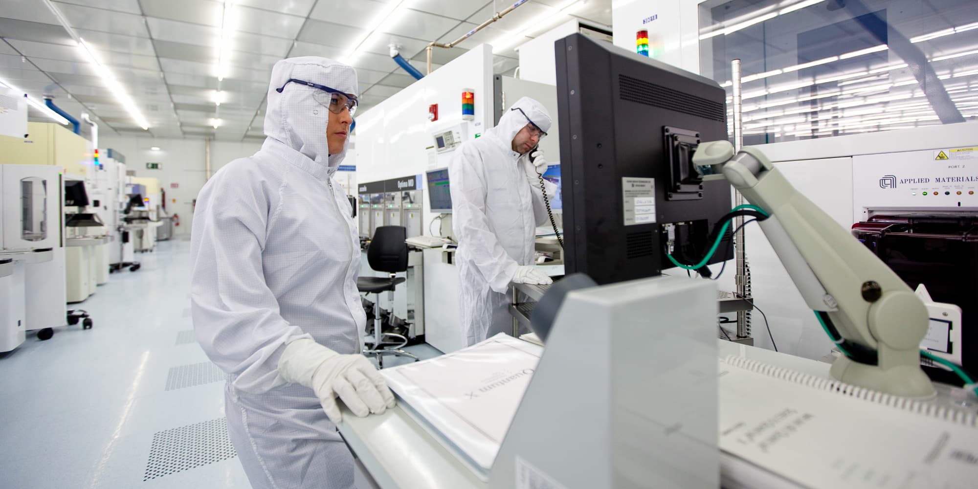 Quantum-computer-research Researchers in a cleanroom monitor semiconductor equipment for quantum device fabrication.