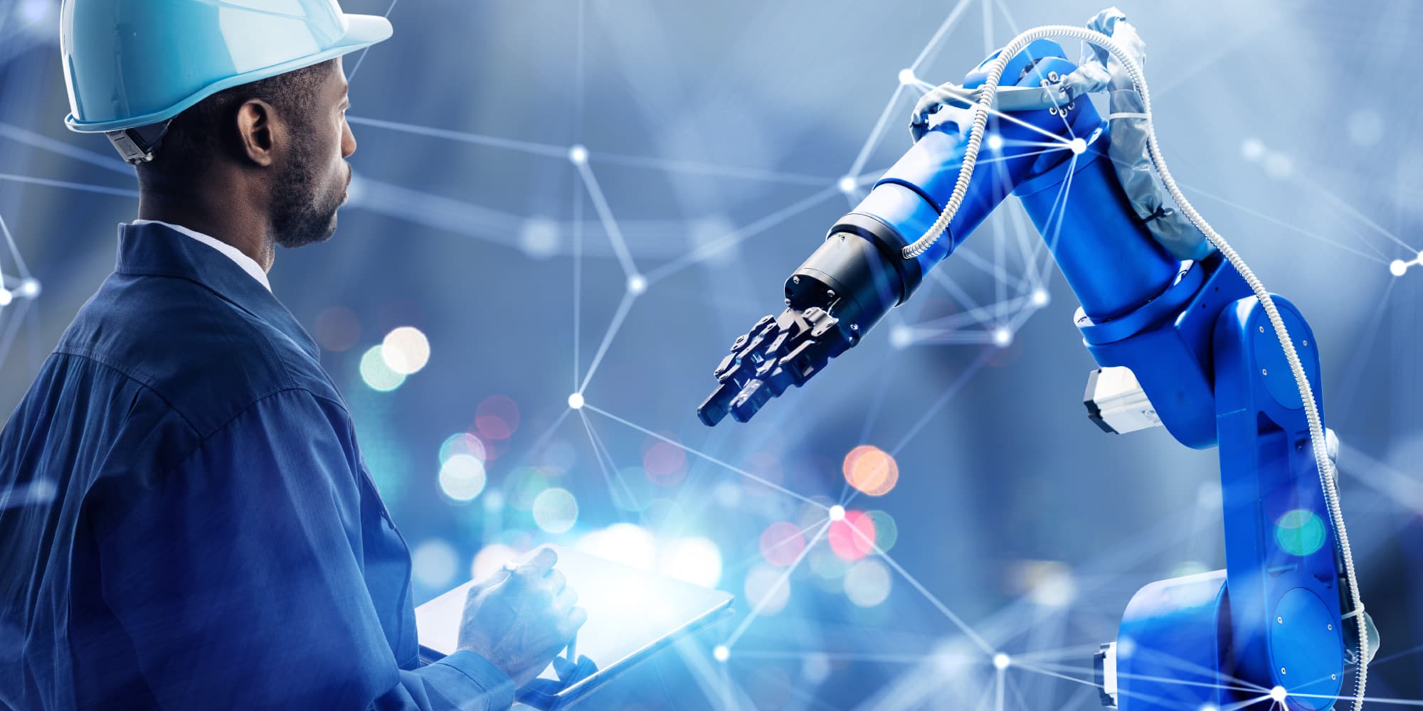 Robotics-technology-for-Industry Engineer in a hard hat faces a blue industrial robot arm while holding a tablet, with a digital network overlay.