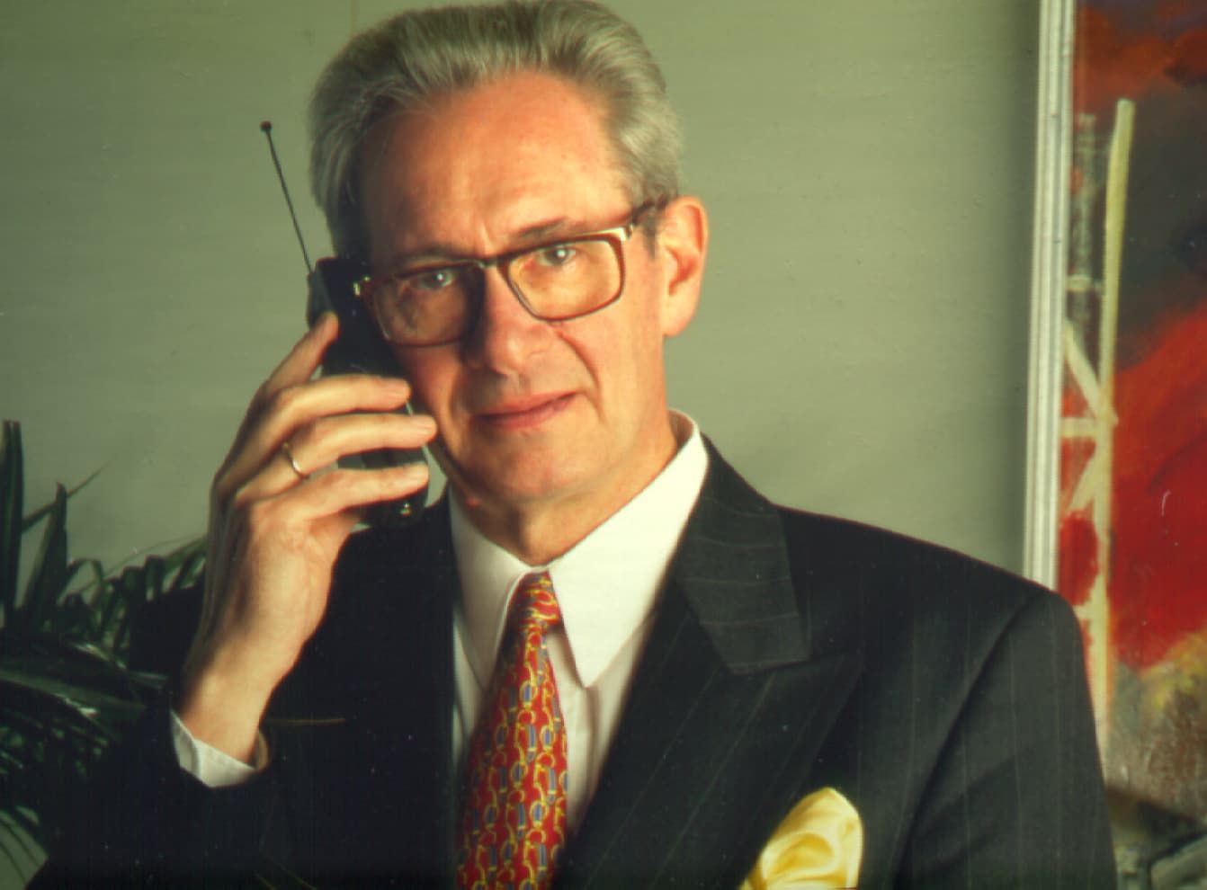 Roger-van-Overstraeten Baron Roger Van Overstraeten in a suit, holding a mobile phone to his ear