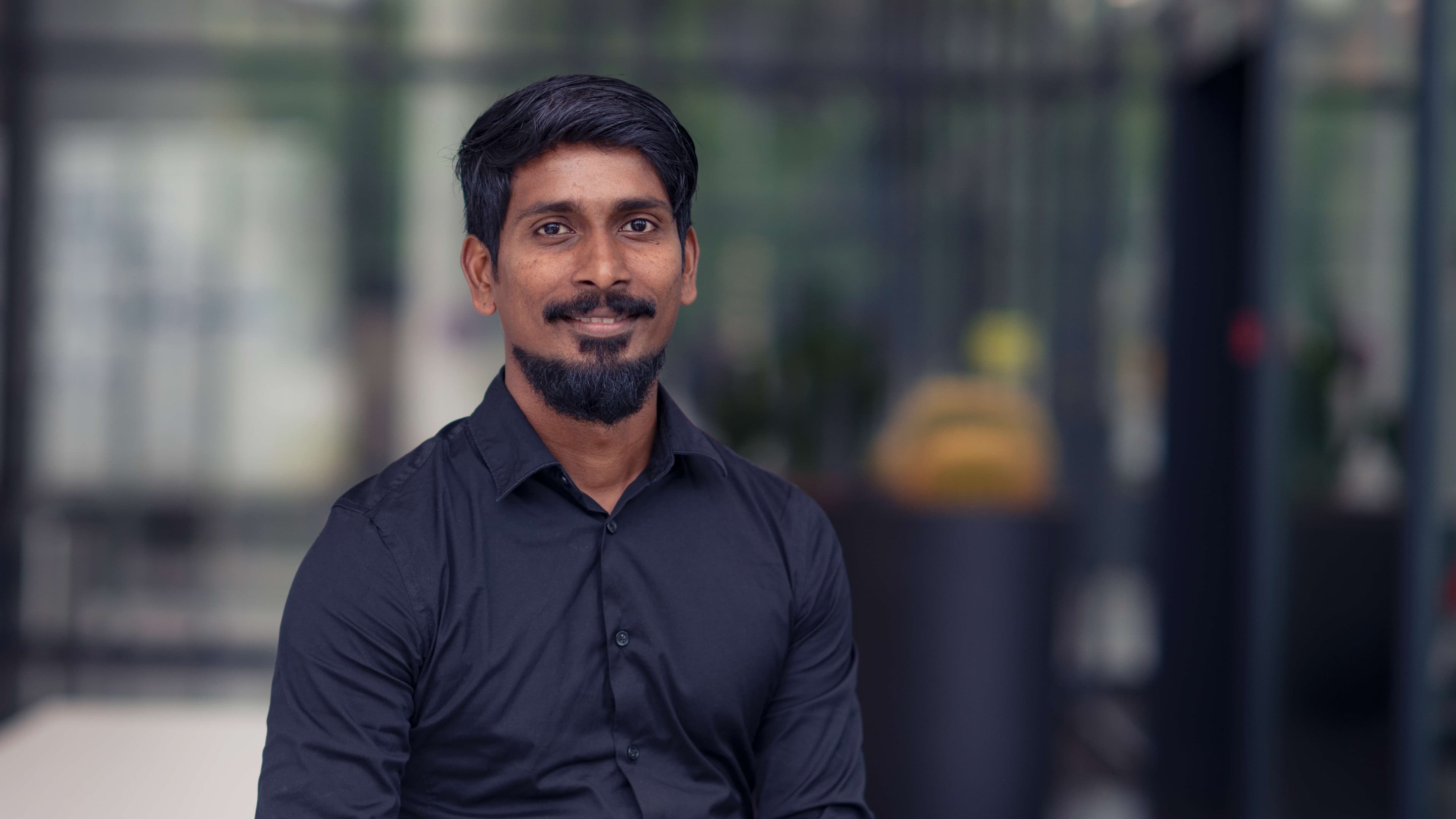 Rohith%20Acharya Portrait of Rohith Acharya in a black shirt against a blurred outdoor background