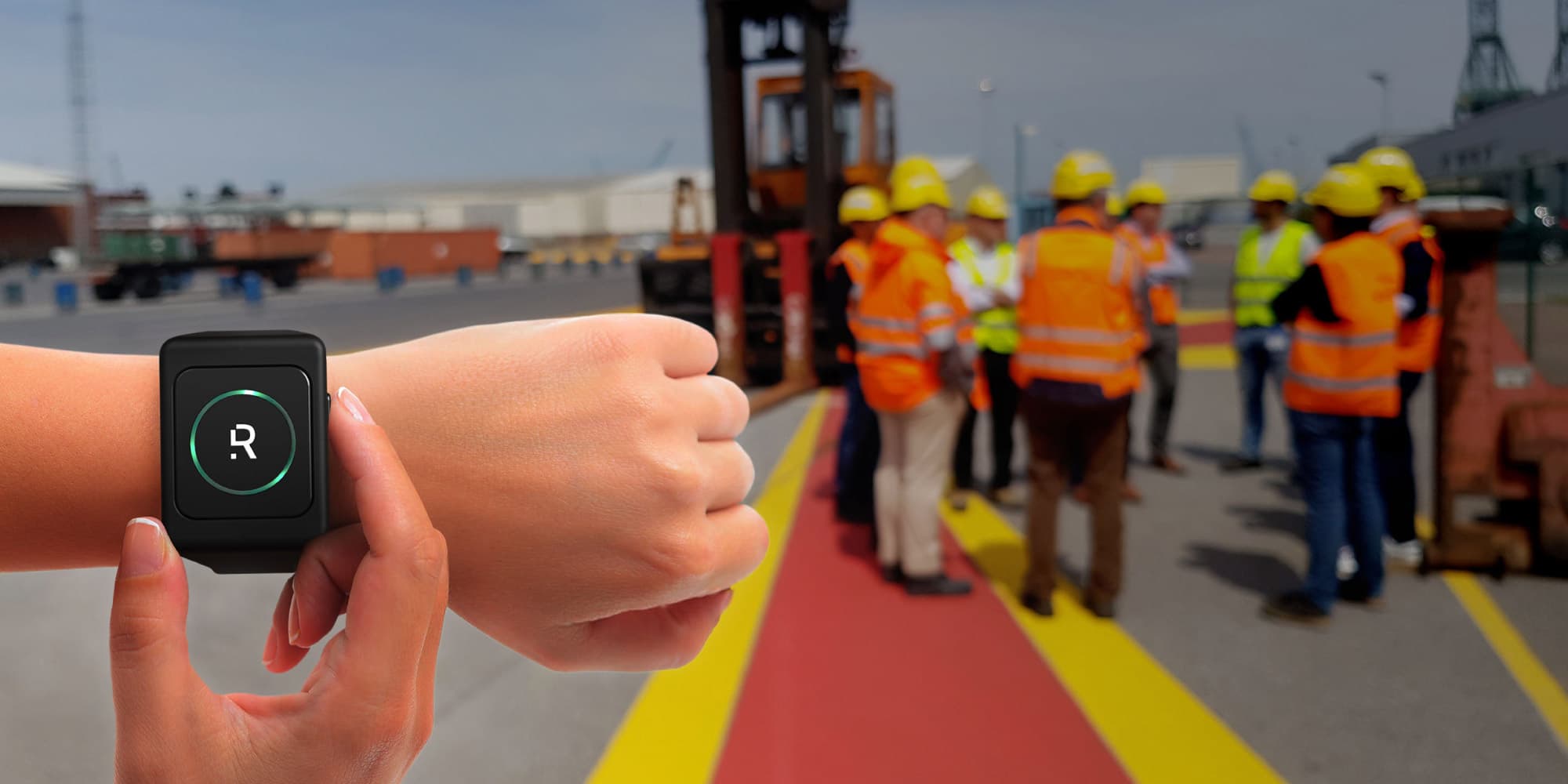 rombit Worker safety wrist device on a wrist in front of a group of construction workers in hard hats