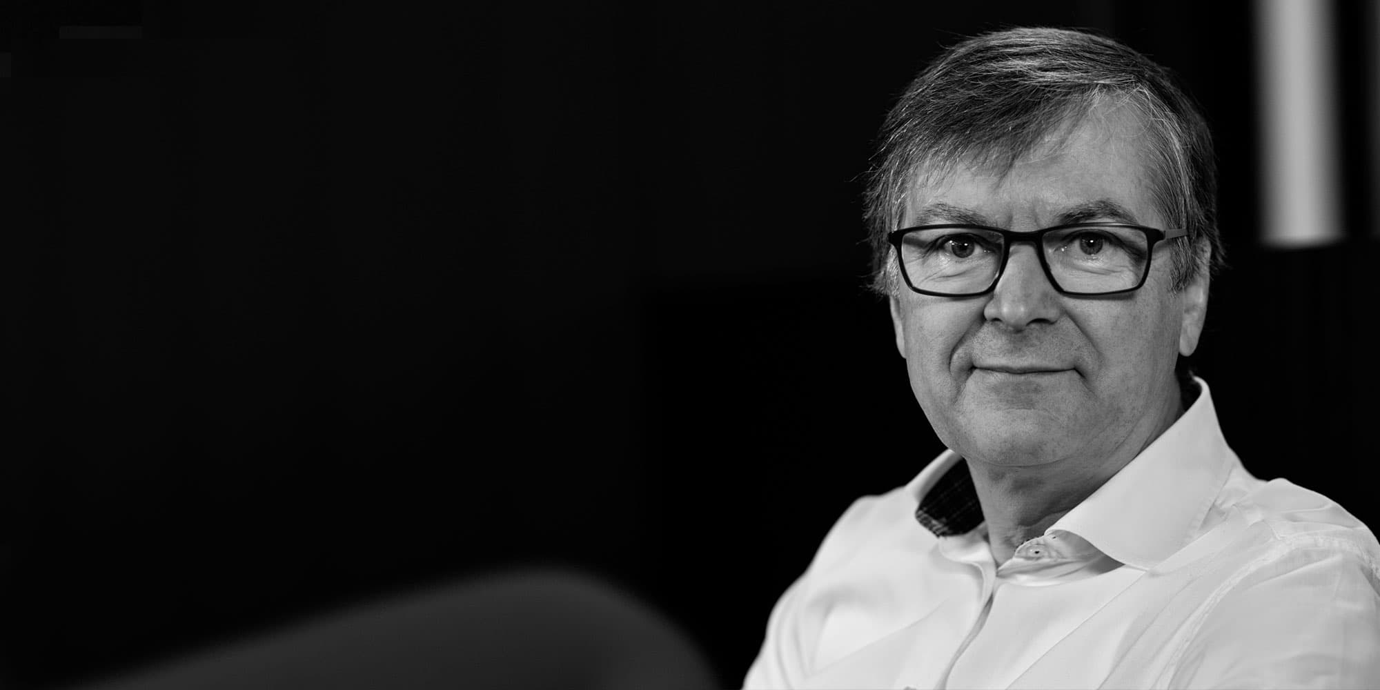 rudy-lauwereins002magazinenew_1 Portrait of Rudy Lauwereins wearing glasses and a white shirt against a dark background