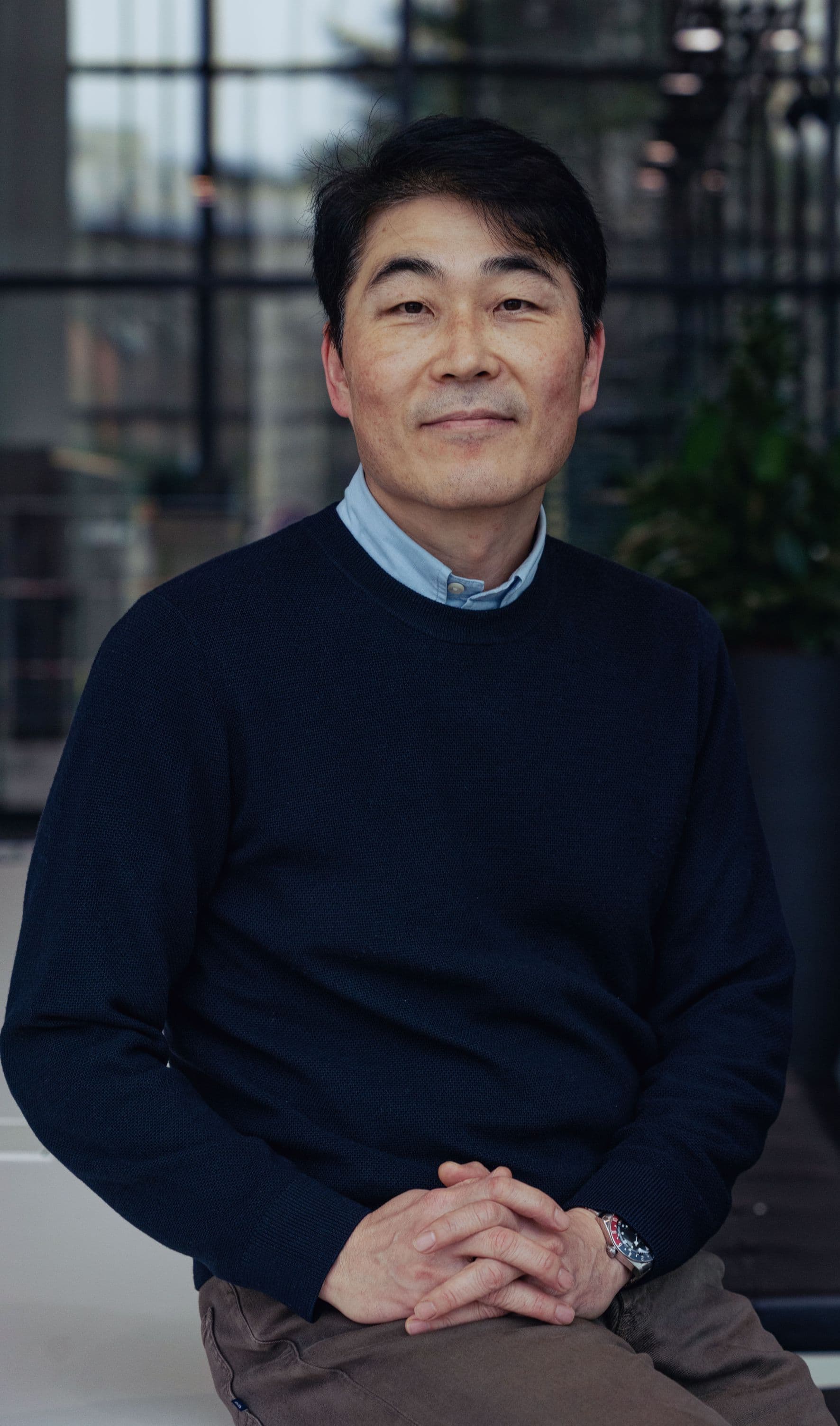 Ryoung-han%20%28Ryan%29%20Kim_2 Portrait of Ryoung-han Kim seated indoors with a blurred lab or office background