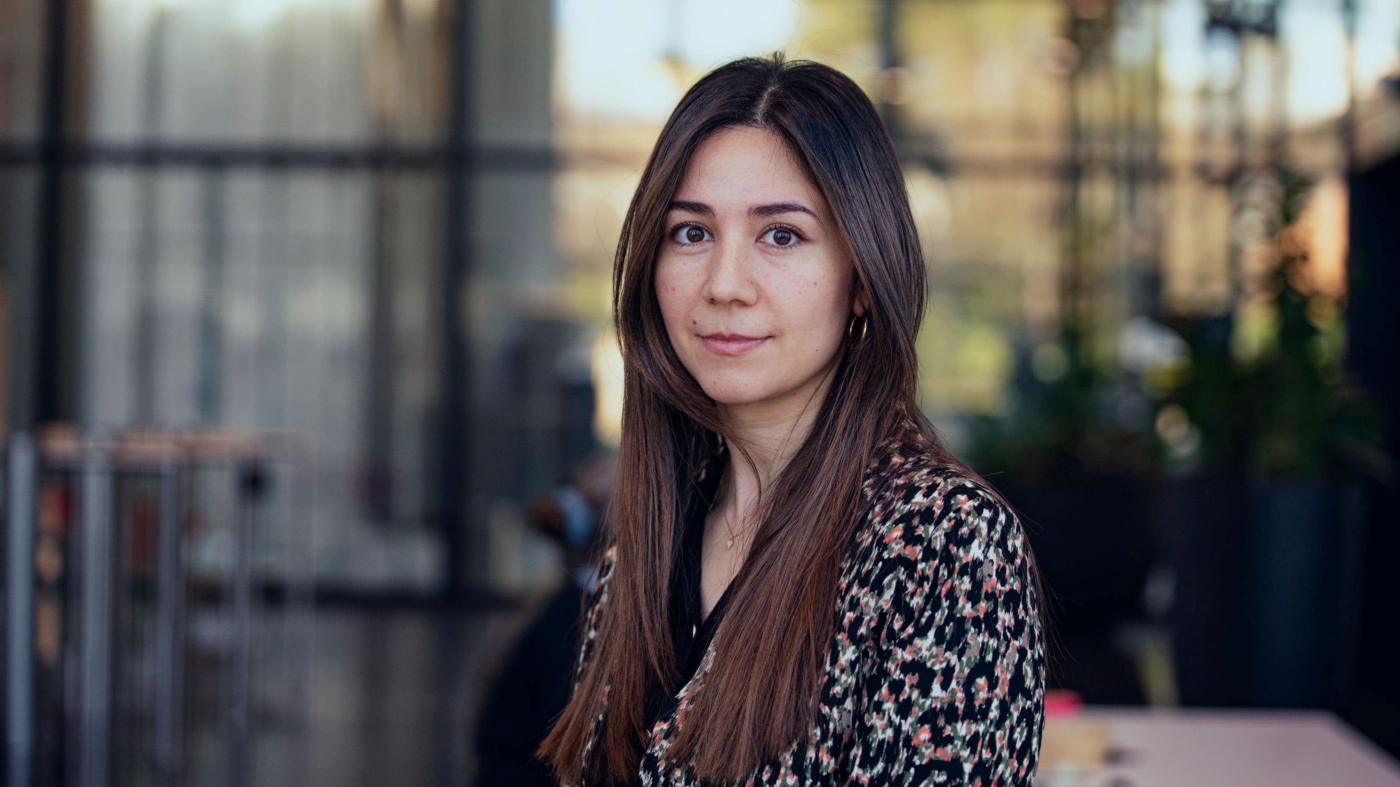 Sana%20Rachidi Portrait of Sana Rachidi standing outdoors, wearing a patterned blouse against a blurred background.