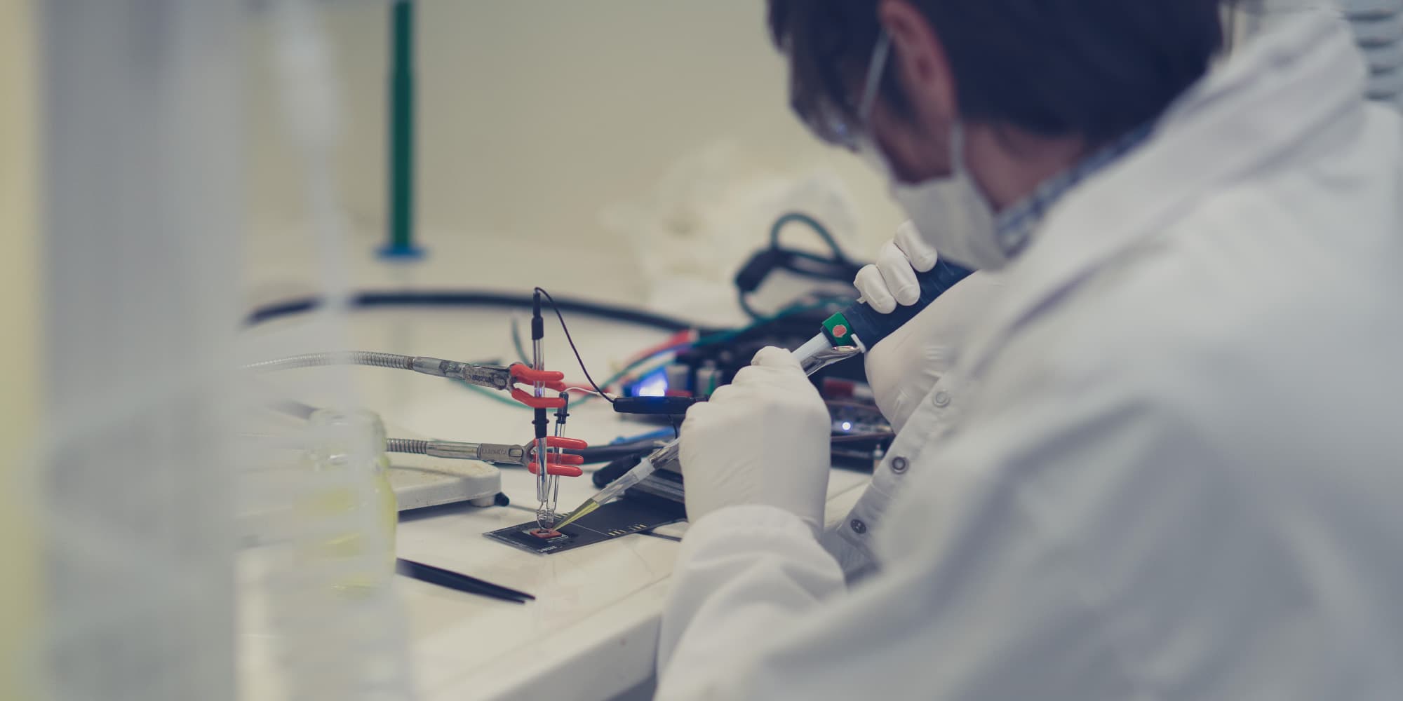 SARCURA-and-imec-to-collaborate-on-high-throughput-cytometry-solution-for-automated-%28T-%29cell-separation%2C-tackling-manufacturing-challenges-of-cell-and-gene-therapies Researchers in a cleanroom handling tubing and a small microfluidic device on a lab bench