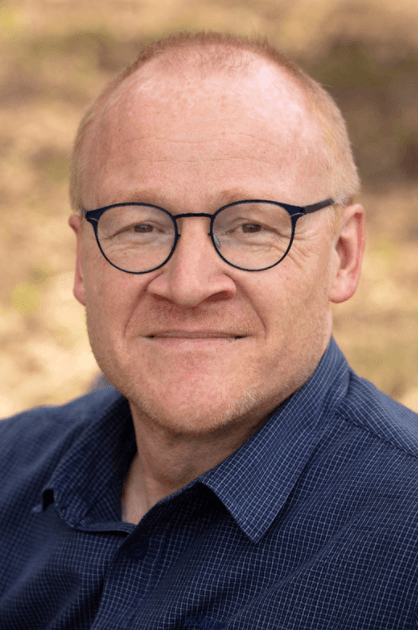 portrait of man with glasses and dark blue shirt Portrait of Jan Theunis wearing round glasses and a dark blue shirt
