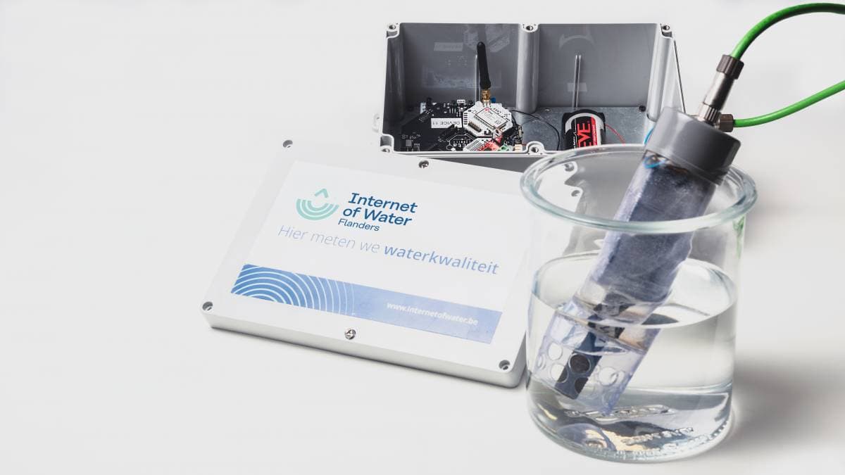 Sensor%20IoW%20Flanders_copyright%20imec Waterkwaliteitssensor in een glazen beker, verbonden met een draadloze monitoringsunit