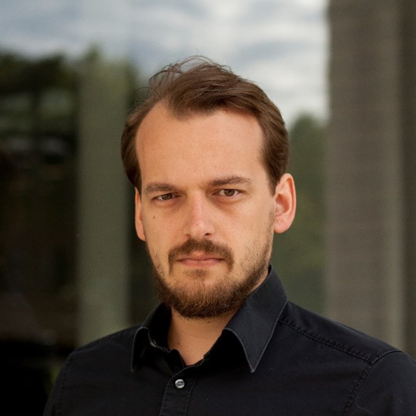 SiegfriedMercelis Portrait of Siegfried Mercelis in a dark shirt, standing outdoors against a blurred background