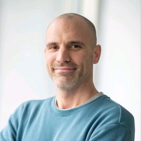 Simon%20Devos Portrait of Simon Devos, Manager of the VIB Proteomics Core, in a teal sweater against a light background.