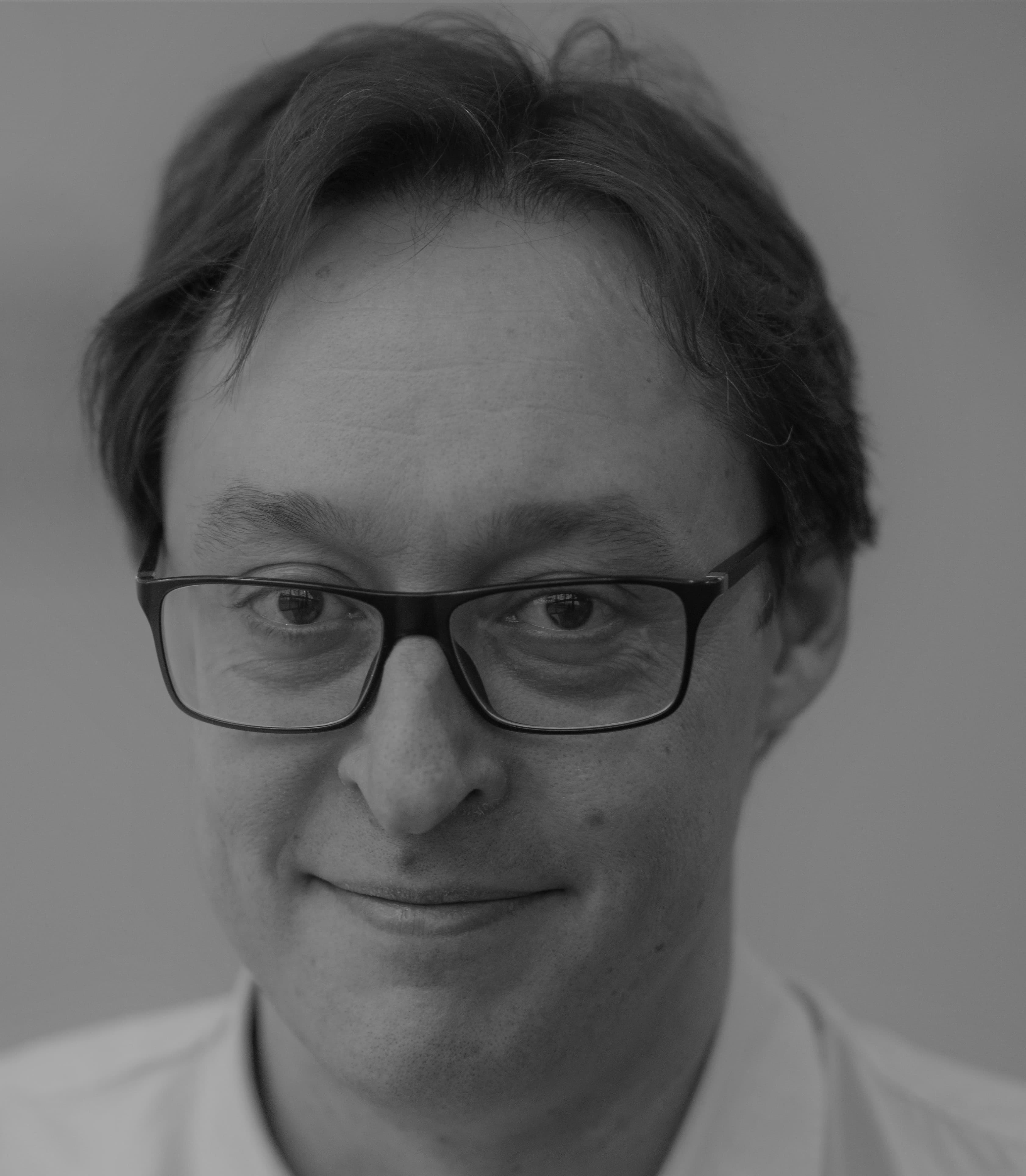 Simone.Severi004 Black-and-white headshot of Simone Severi wearing glasses, facing the camera.