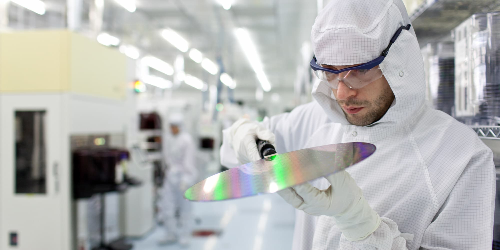 sin-photonics Cleanroom researcher inspecting a reflective silicon wafer in a photonics lab