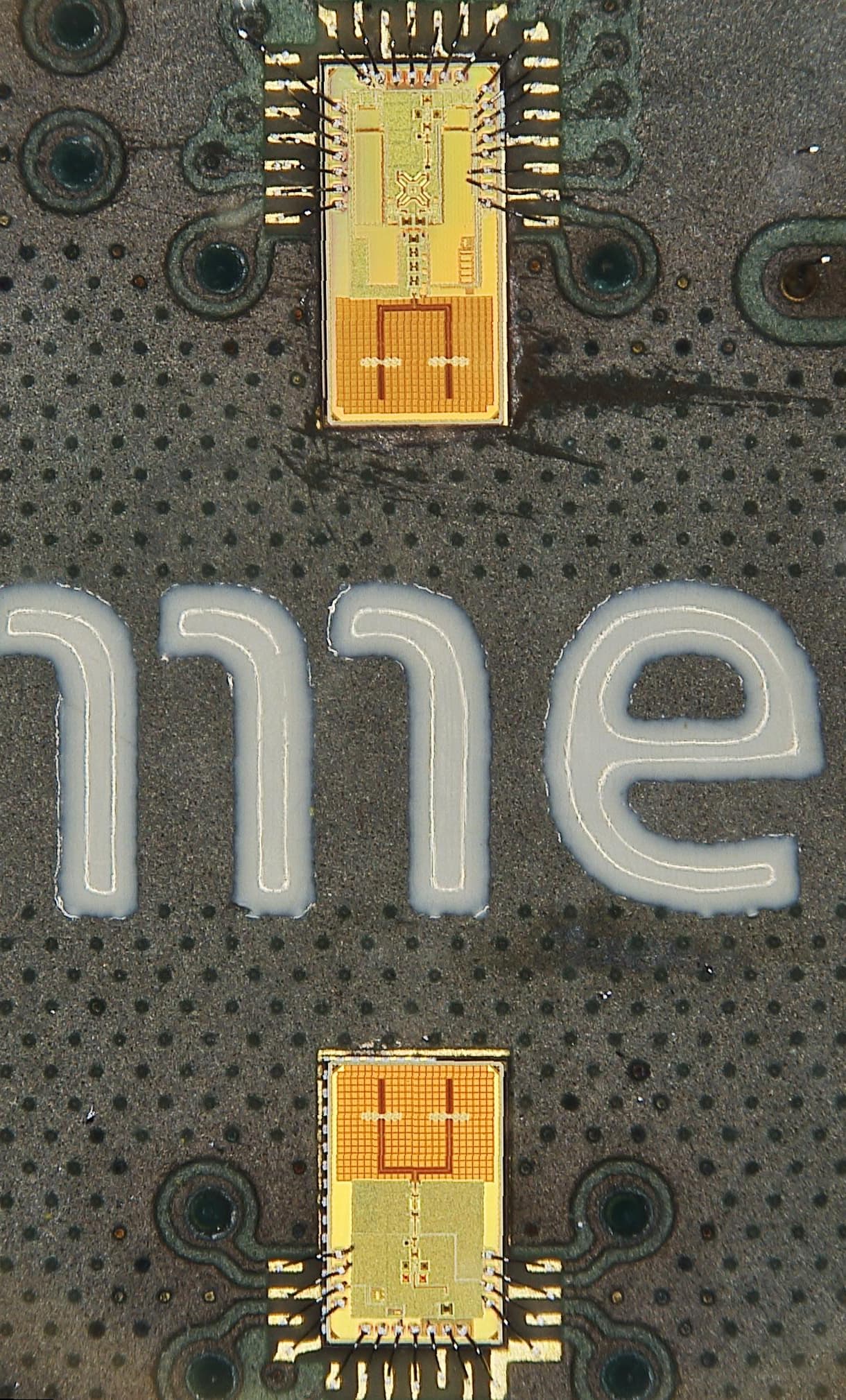 Single%20radar%20%28close-up%29_0 Close-up of two tiny semiconductor chips mounted on a dark circuit board with large white lettering.