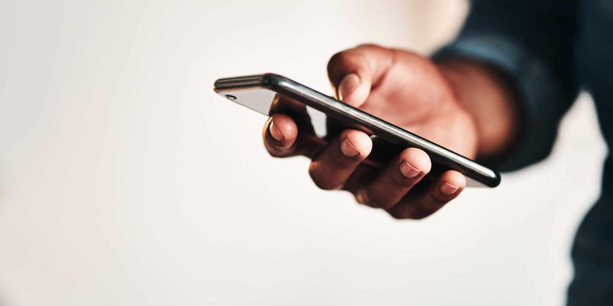 smartphone Hand holding a smartphone against a blurred background