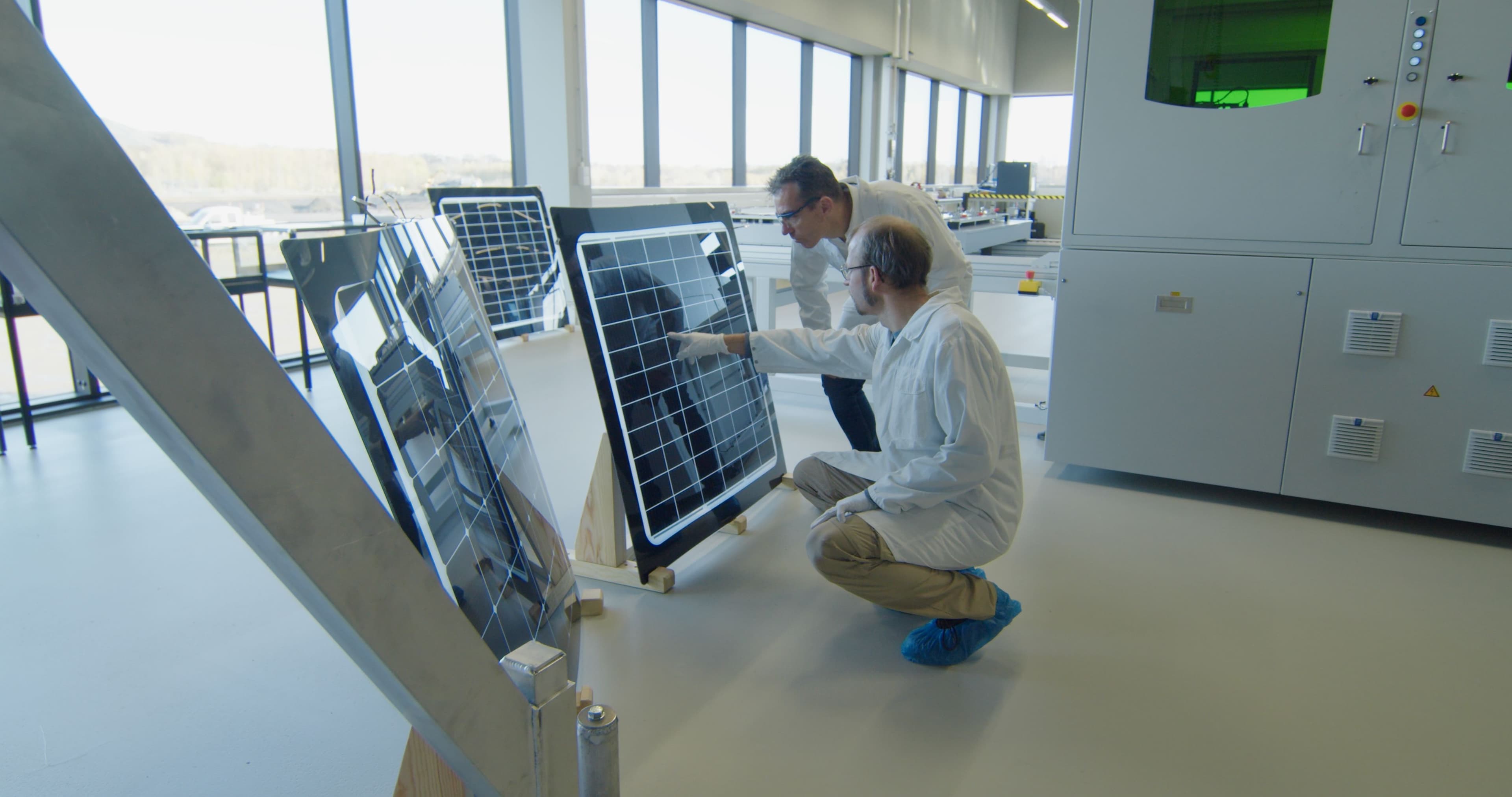 SNROOF_zonnepaneel_01 Researchers inspecting curved solar panels in a lab