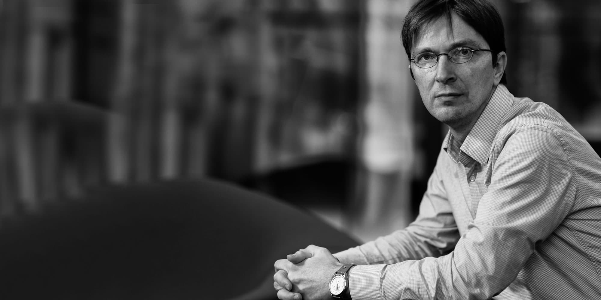 soeren-Steudel002magazinenew_1 Black-and-white portrait of Soeren Steudel seated indoors with hands clasped, looking at the camera.