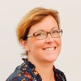 sofie_van_hoecke_1 Portret van Sofie Van Hoecke, glimlachend met een bril tegen een lichte achtergrond