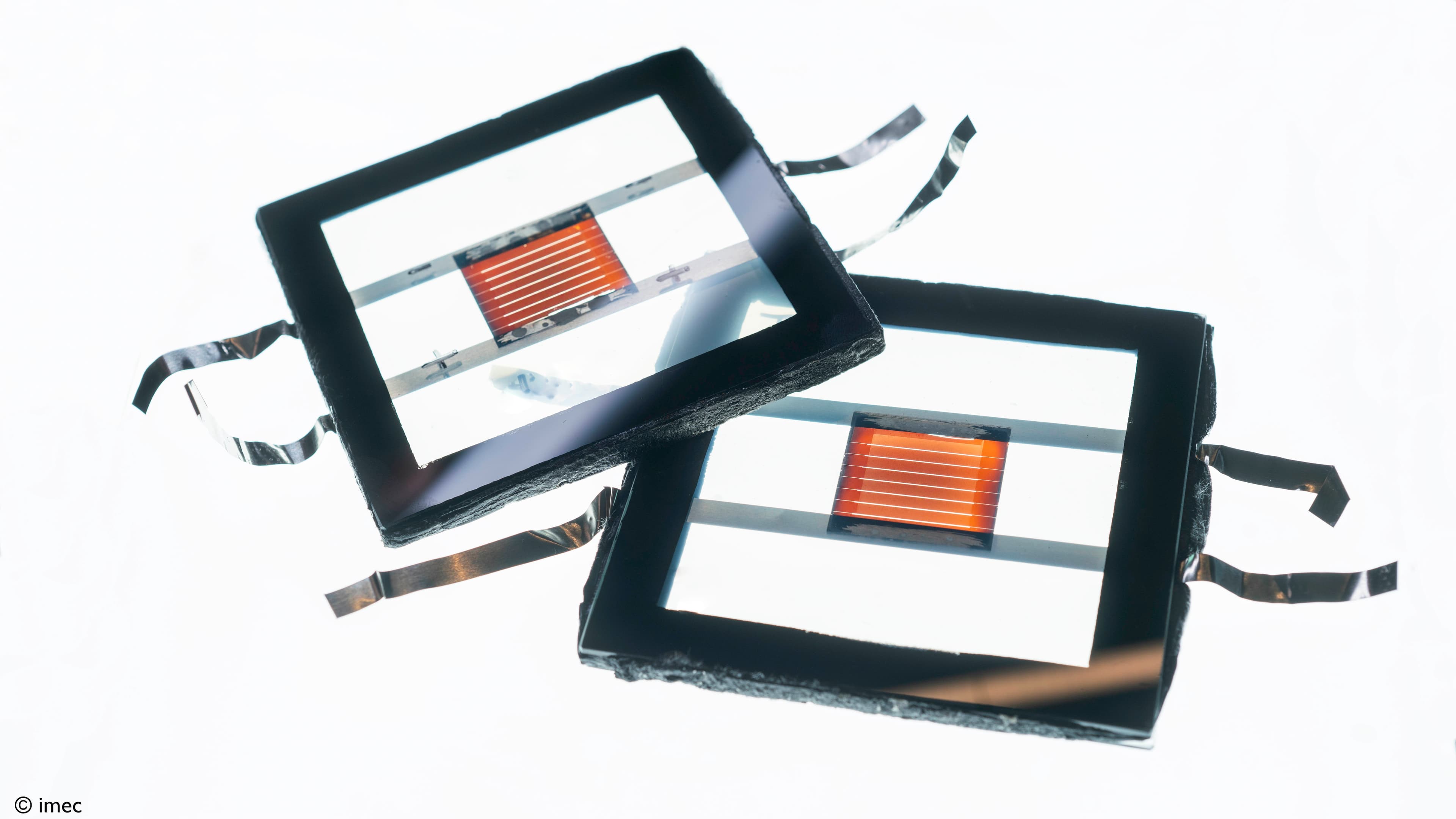 Solar-perovskite-mini-modules001%20%281%29_0 Two small perovskite solar modules with orange active areas, overlapping on a white background