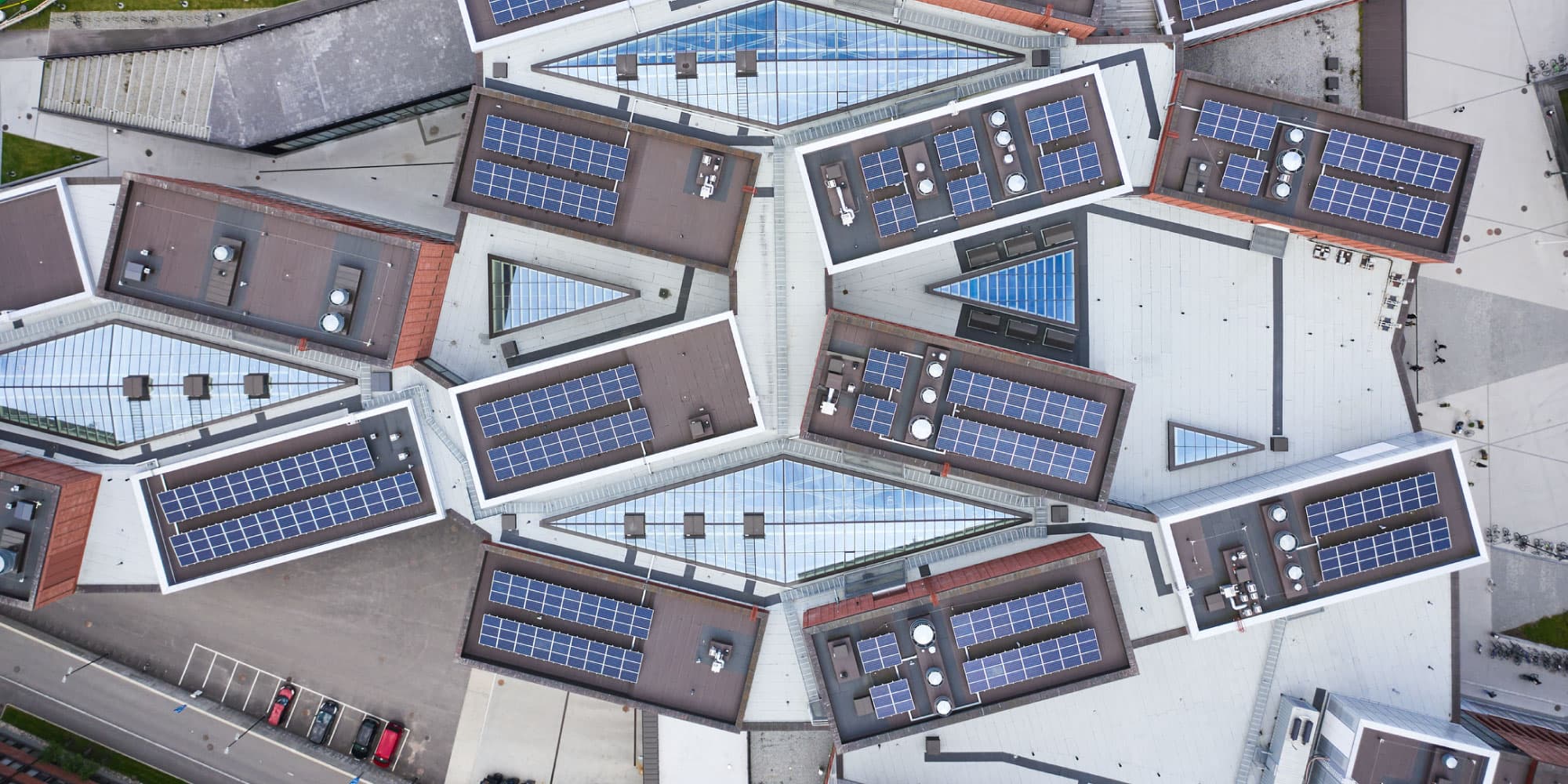 solar Aerial view of a building complex with many rooftop solar panels and glass skylights