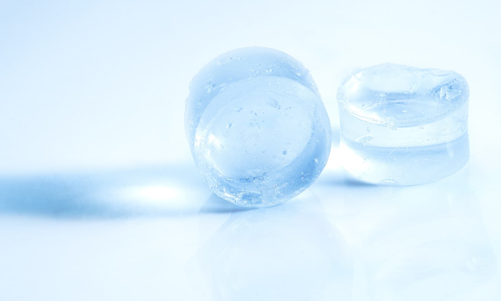 SolidStateBatteries_2 Two translucent blue battery cell samples on a white reflective surface