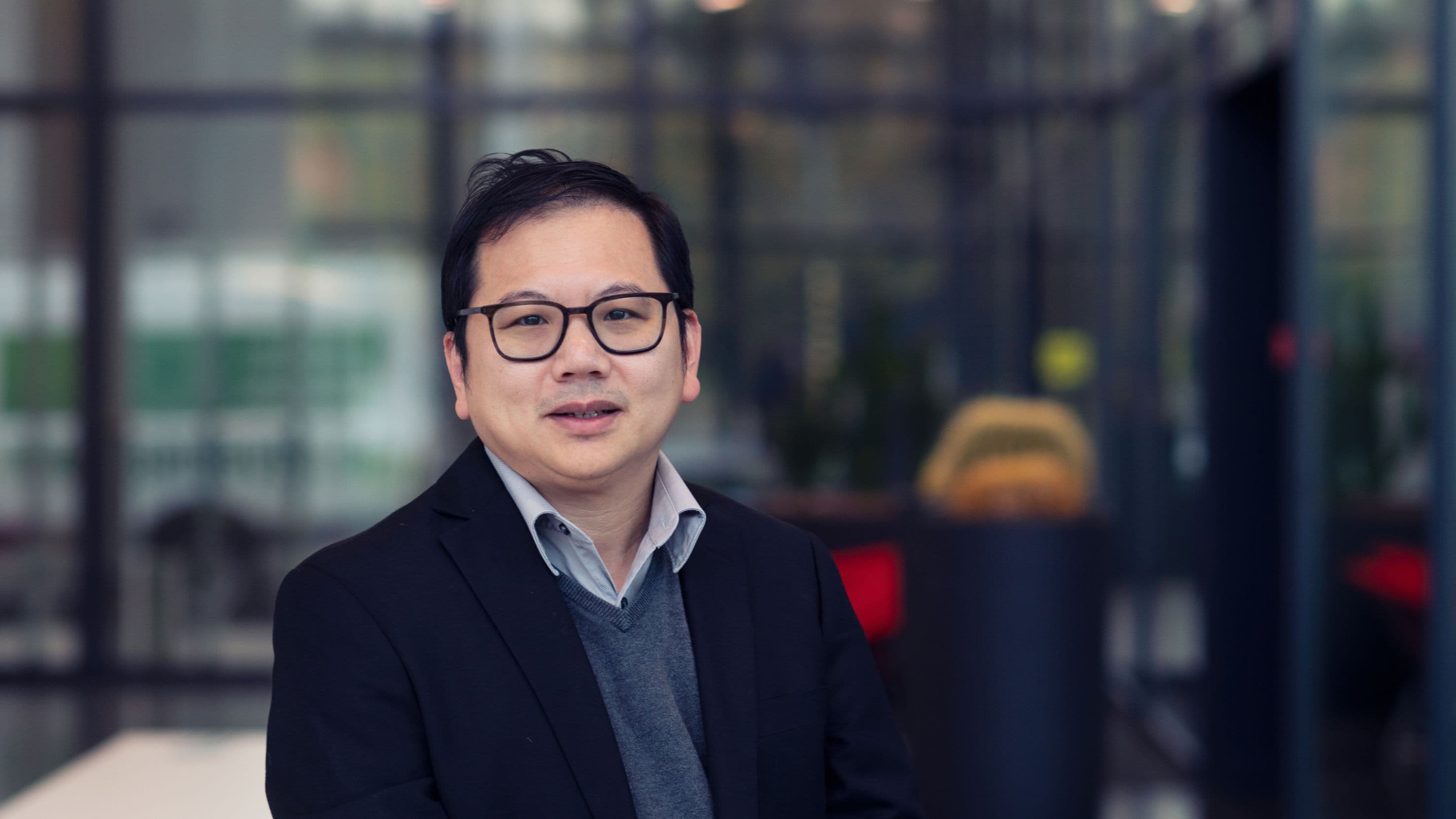 Soon%20Aik%20Chew Portrait of Soon Aik Chew in a blazer and glasses, standing in front of a blurred laboratory background