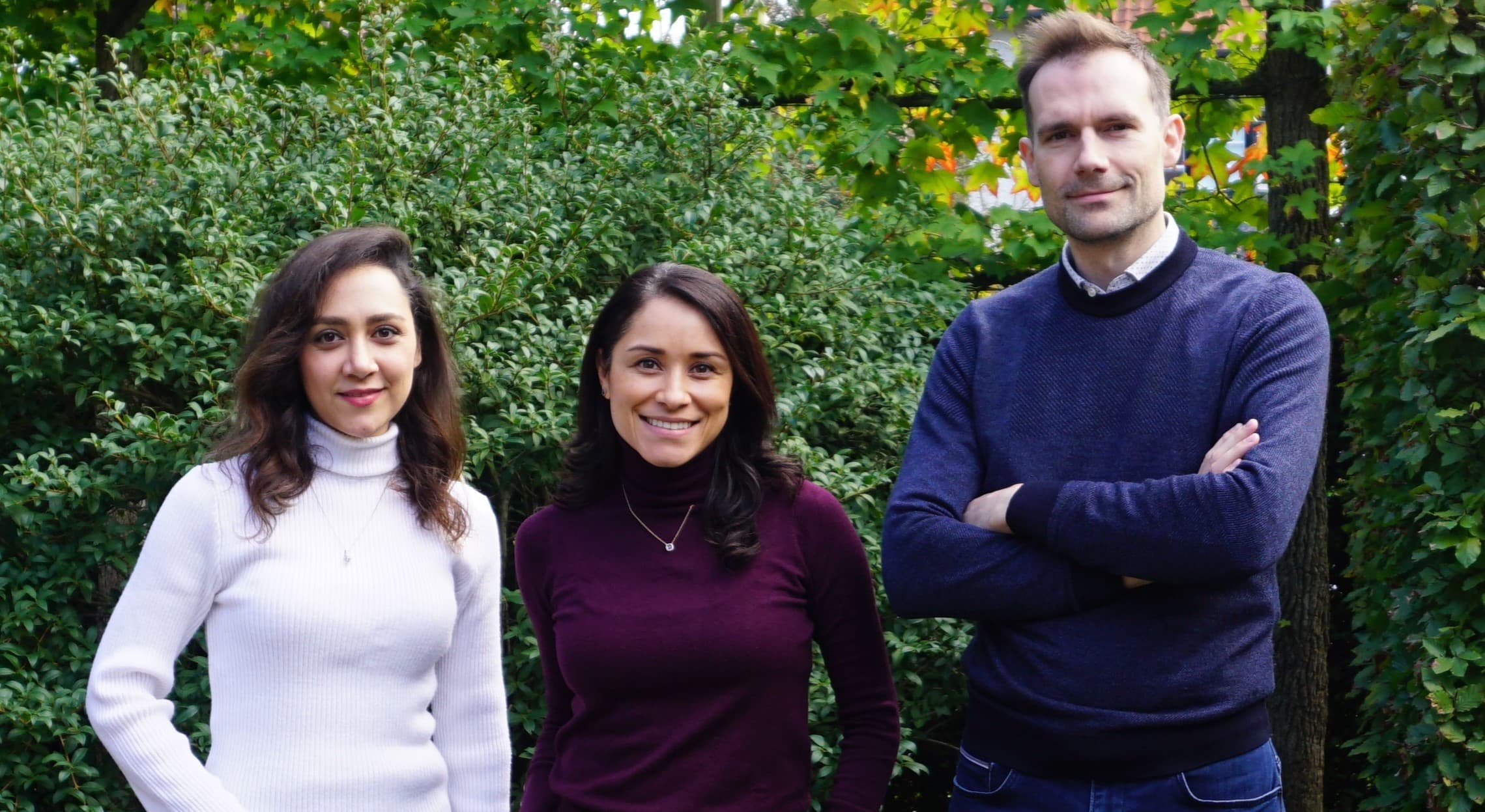 Specifix%20Team_1 Three team members posing outdoors in front of leafy greenery