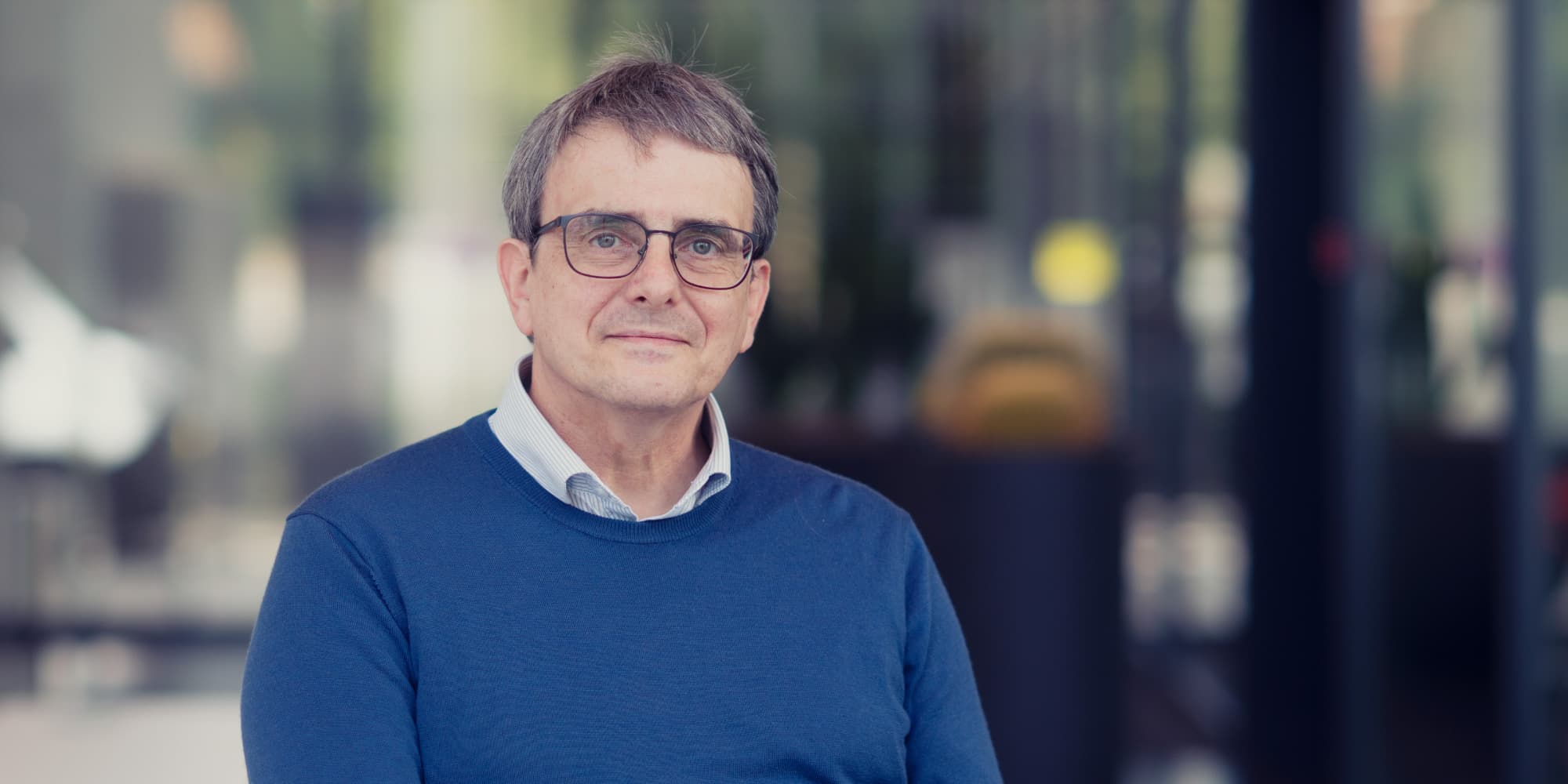Stefaan-Decoutere-2000x1000 Portrait of imec fellow Stefaan Decoutere in a blue sweater and glasses