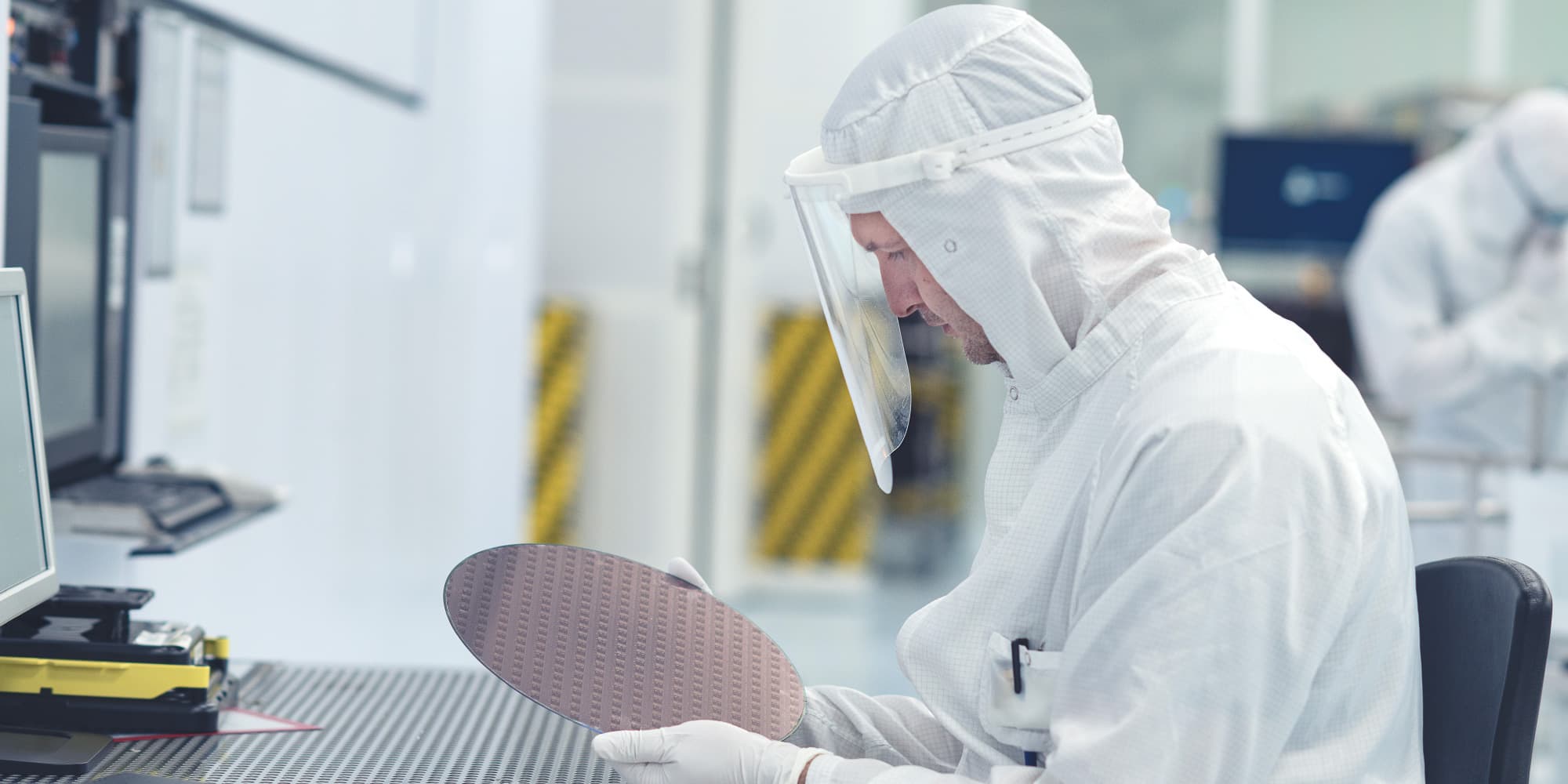 Store-technology-centers Researcher in a cleanroom inspecting a semiconductor wafer