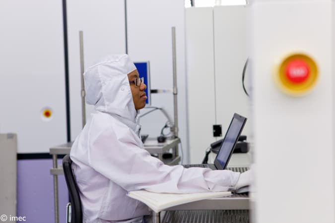 sustainable%20semiconductor Researcher in a cleanroom working at a laptop in a semiconductor lab