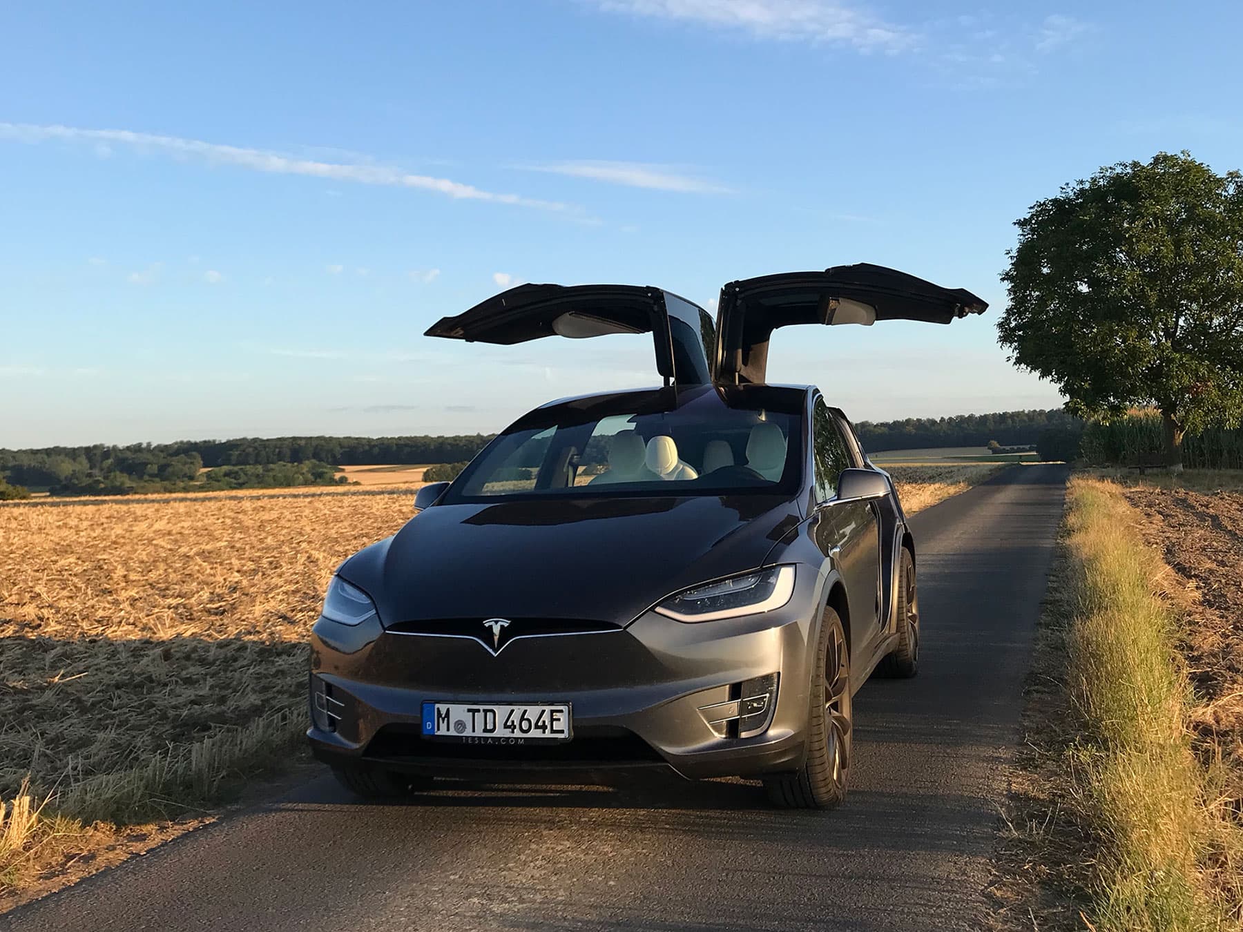 Tesla_Model_X Tesla Model X with falcon-wing doors raised on a rural road