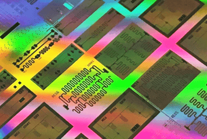 Testchip-superconducting-qubits Colorful close-up of a superconducting qubit test chip with multiple patterned rectangular dies