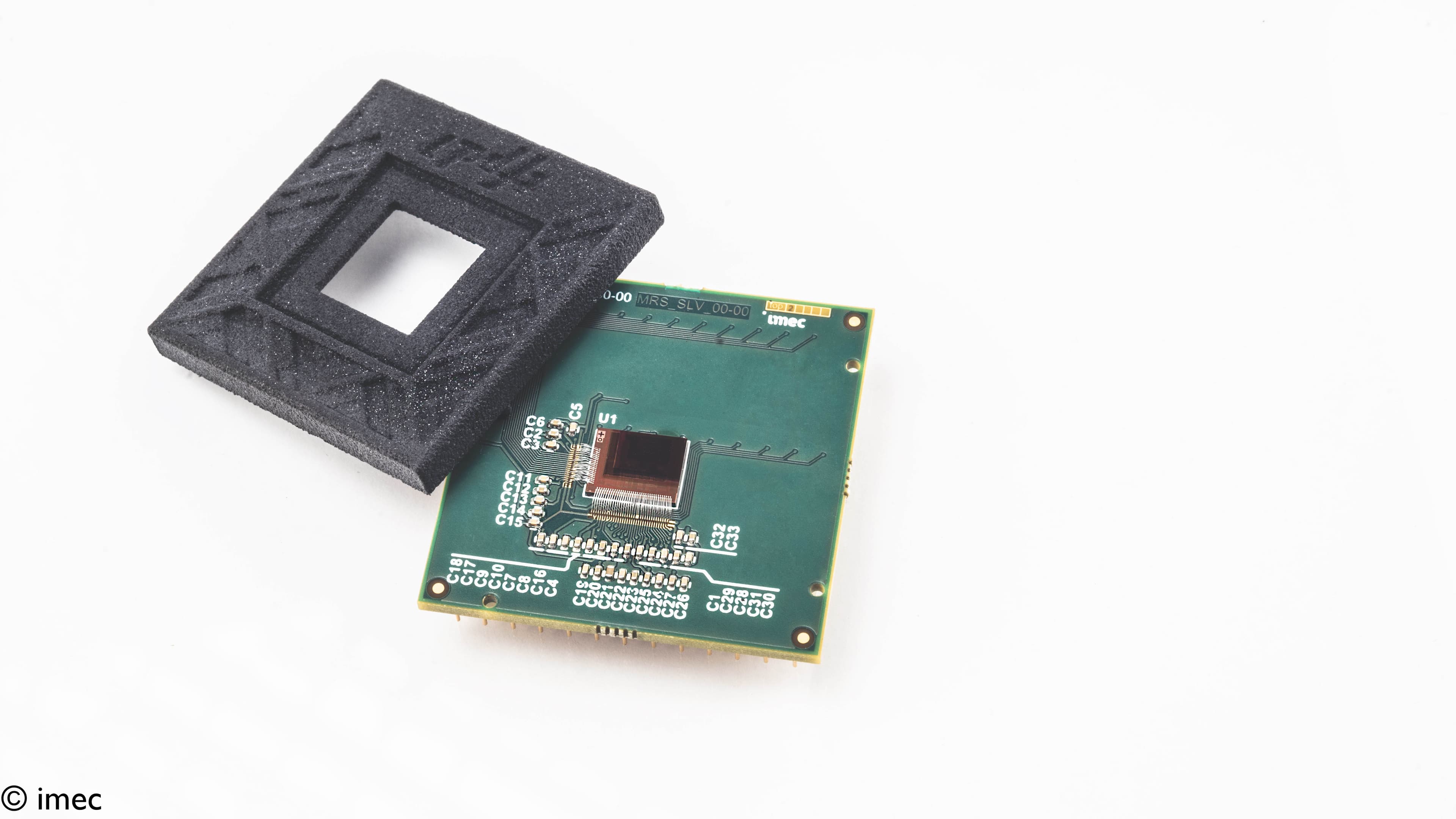 Thin-film photodetector chip on circuit board Thin-film photodetector chip mounted on a green circuit board with a black foam holder above it.