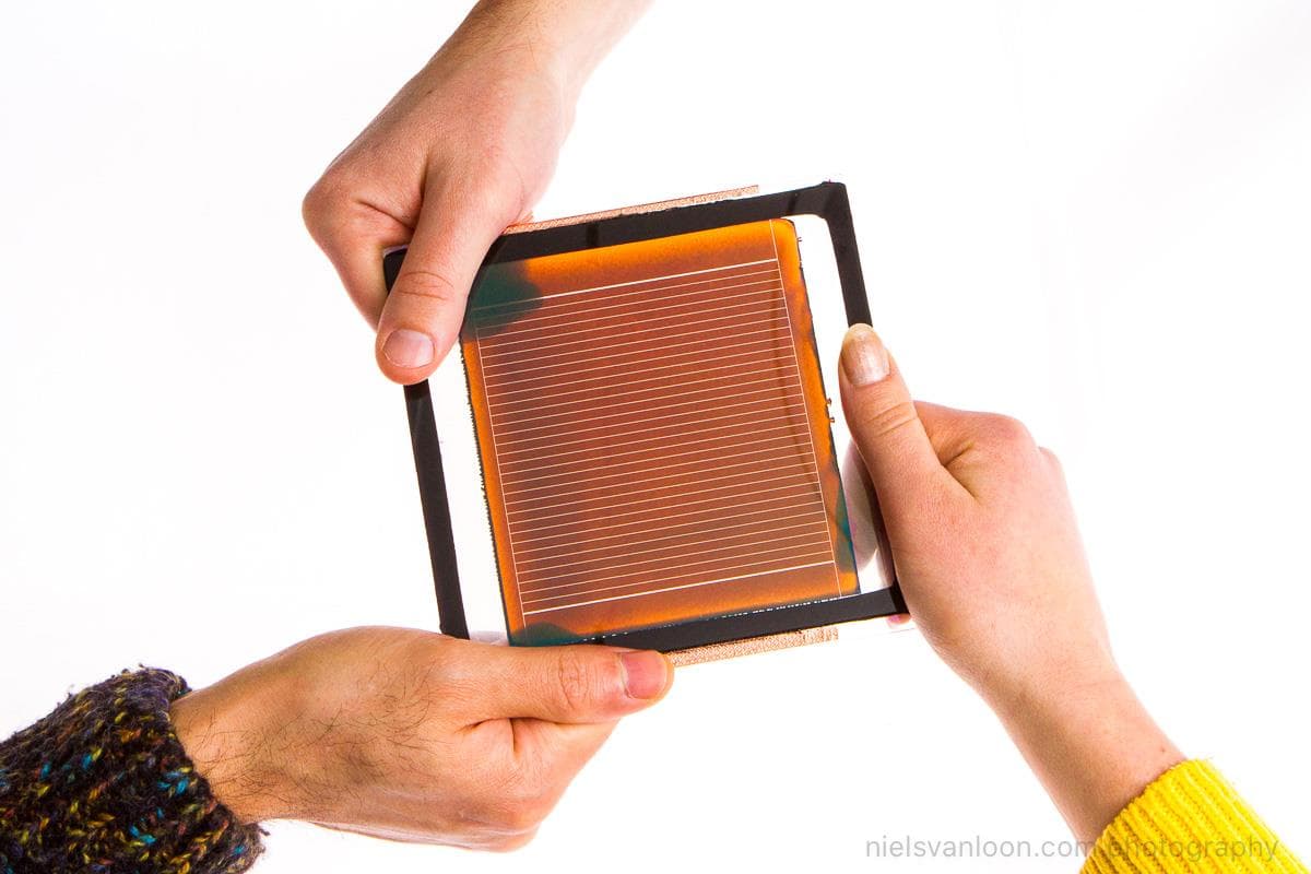 Thin-Film_Image_3 Hands holding a thin-film solar module in a square frame