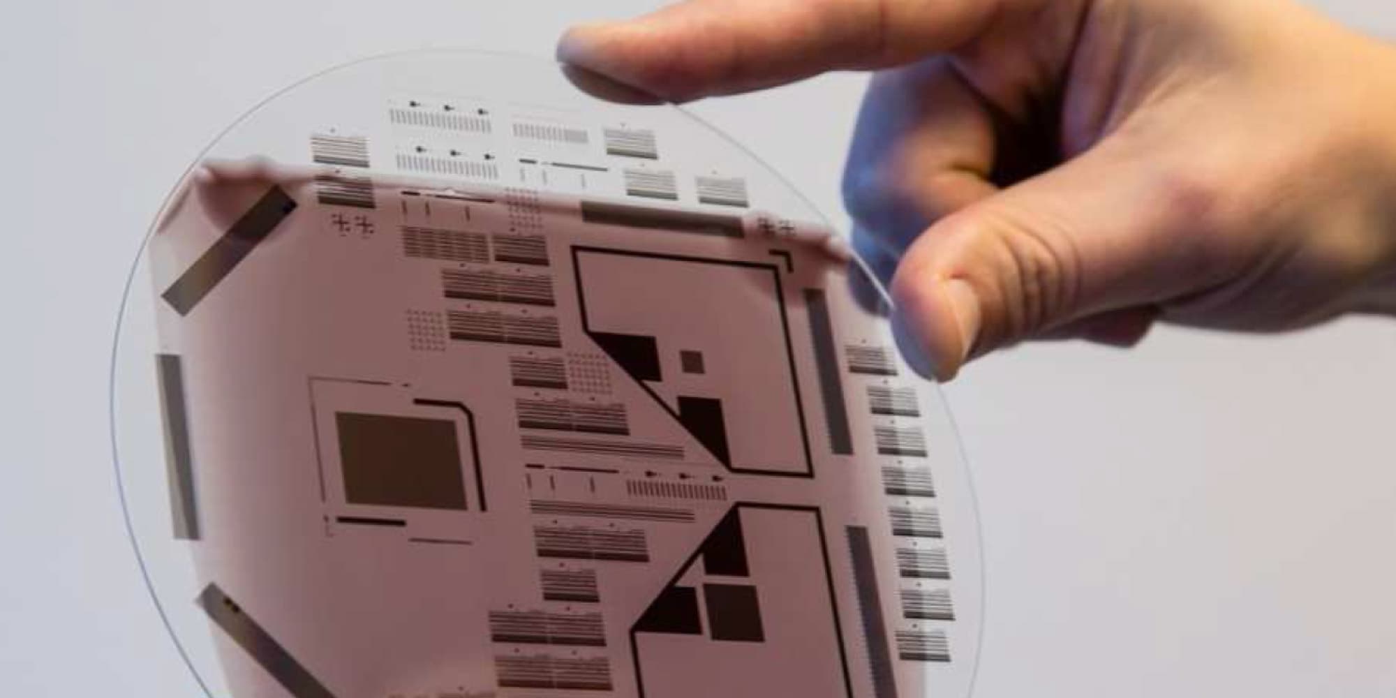thin-film-imagers-sensors_1 Hand holding a transparent circular sensor wafer with patterned test structures