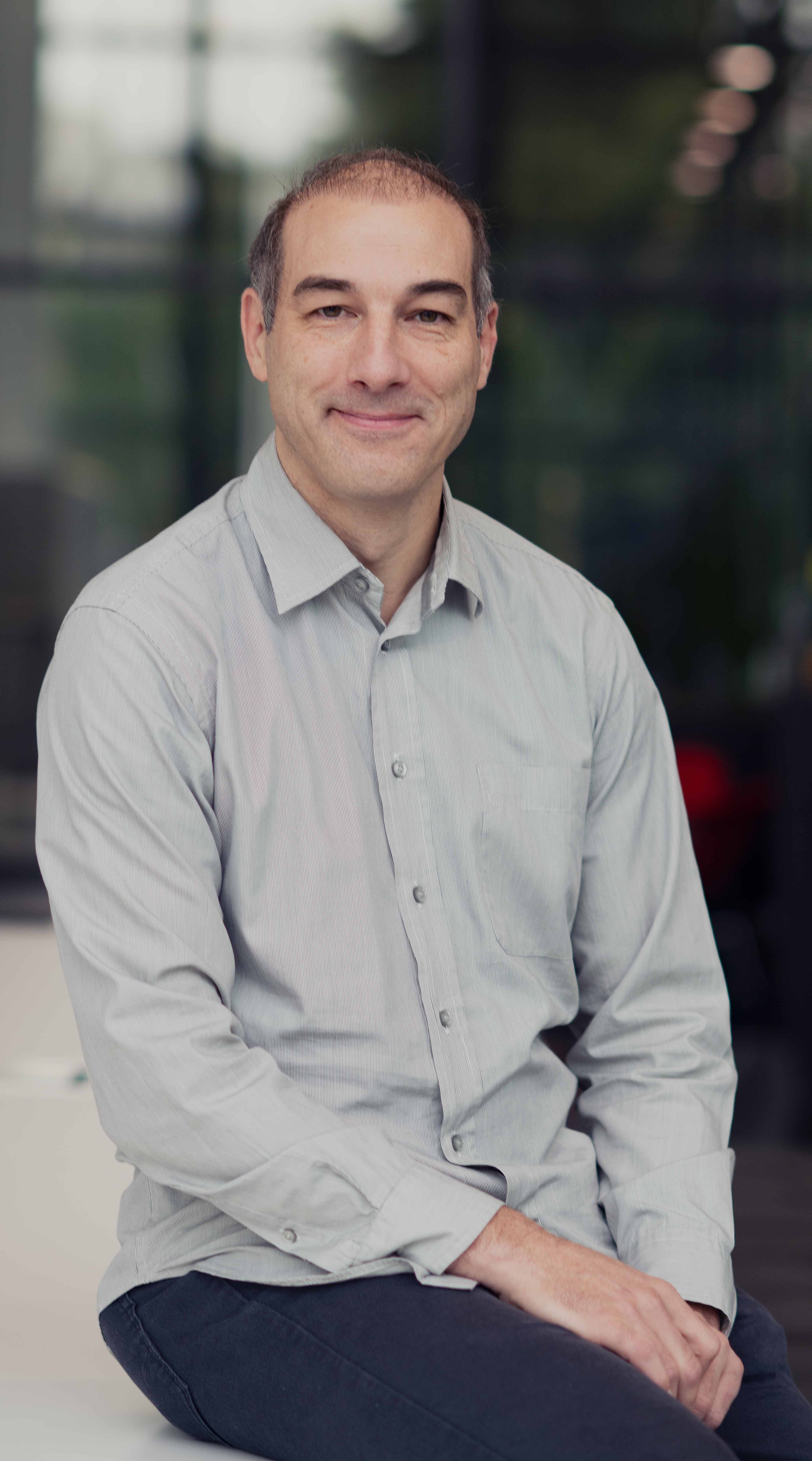Tim-Stakenborg Portrait of Tim Stakenborg, principal member of technical staff at imec, seated in a light gray shirt
