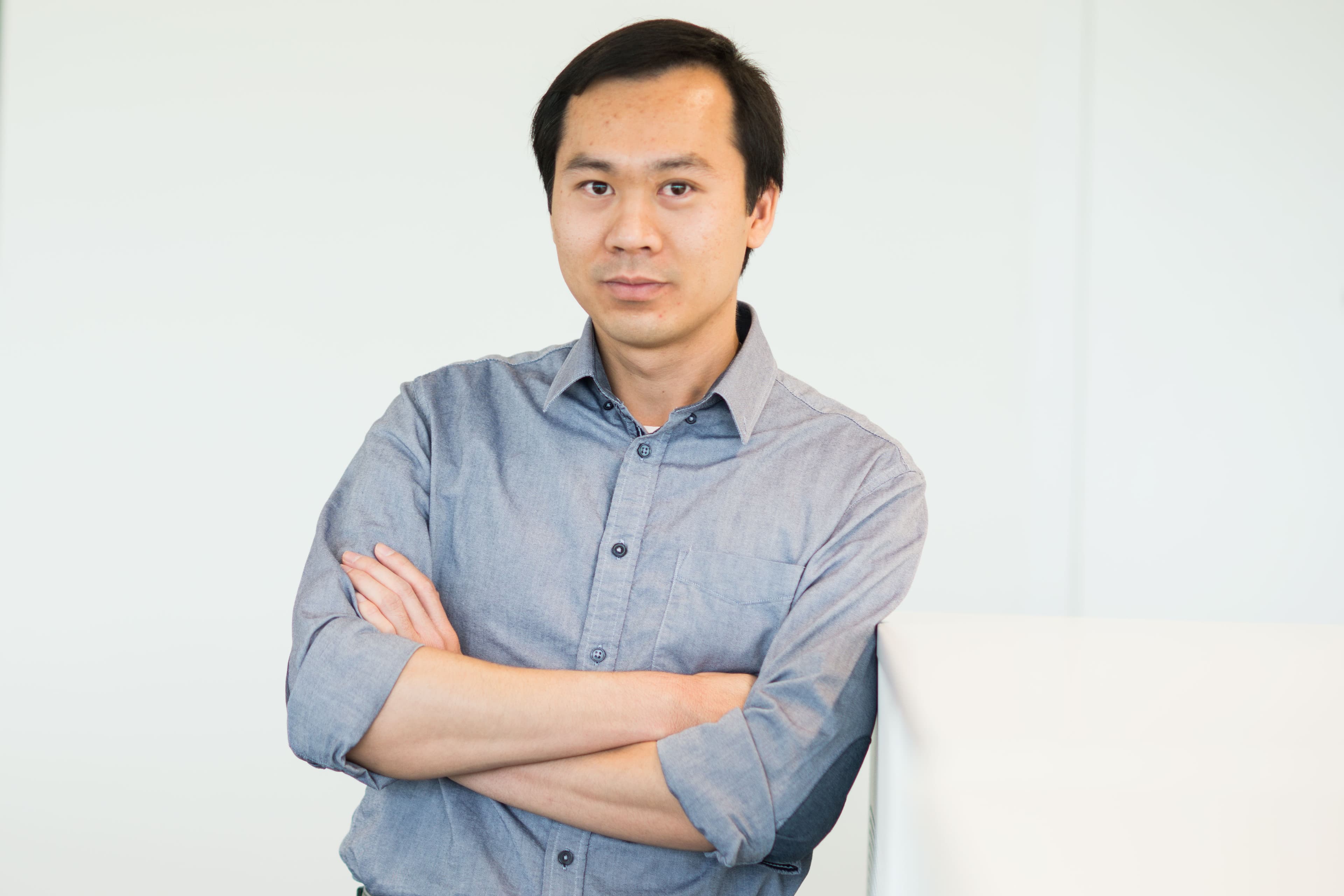 Trong004_1 Portrait of Trong Huynh-Bao with arms crossed against a plain light background.