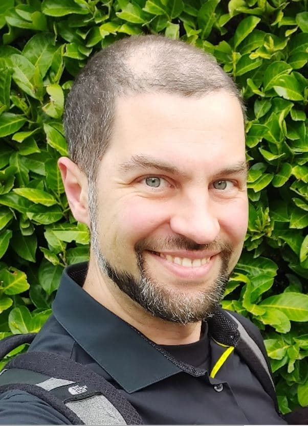 Tsvetan%20Ivanov Smiling researcher in a black shirt in front of a green leafy wall