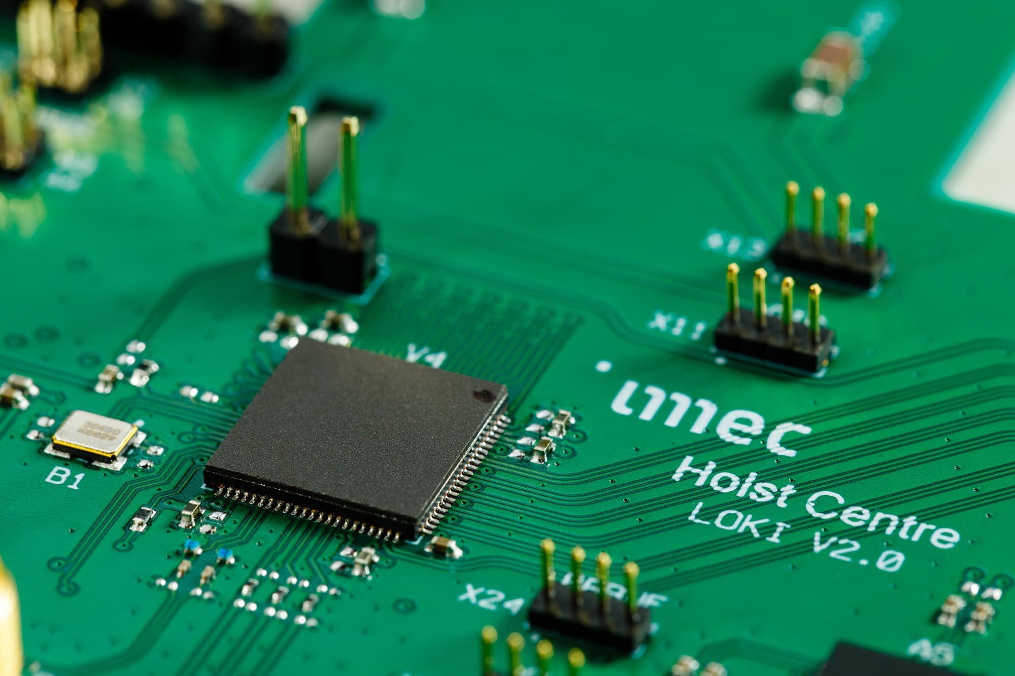 Ultra-Wideband-is-gaining-traction-photo-2 Close-up of a green circuit board with a central chip and pin headers, labeled imec Holst Centre