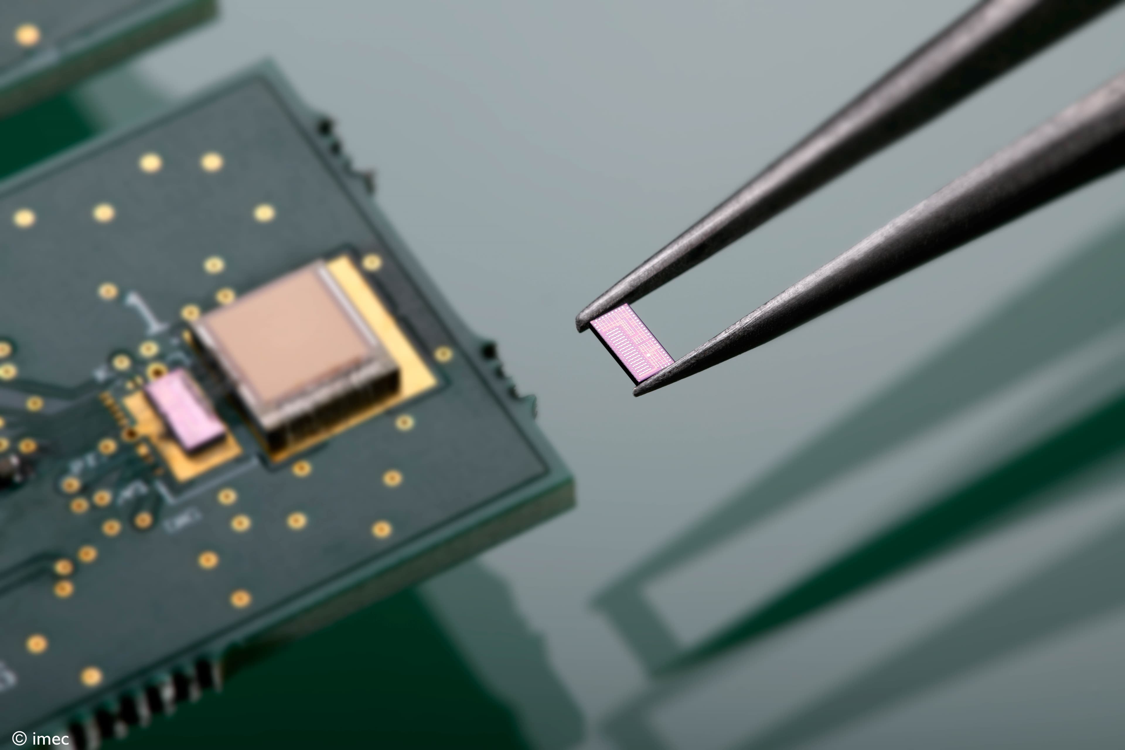 Ultrasound%20powering%20main%20visual_1 Tweezers holding a tiny pink semiconductor chip above a circuit board