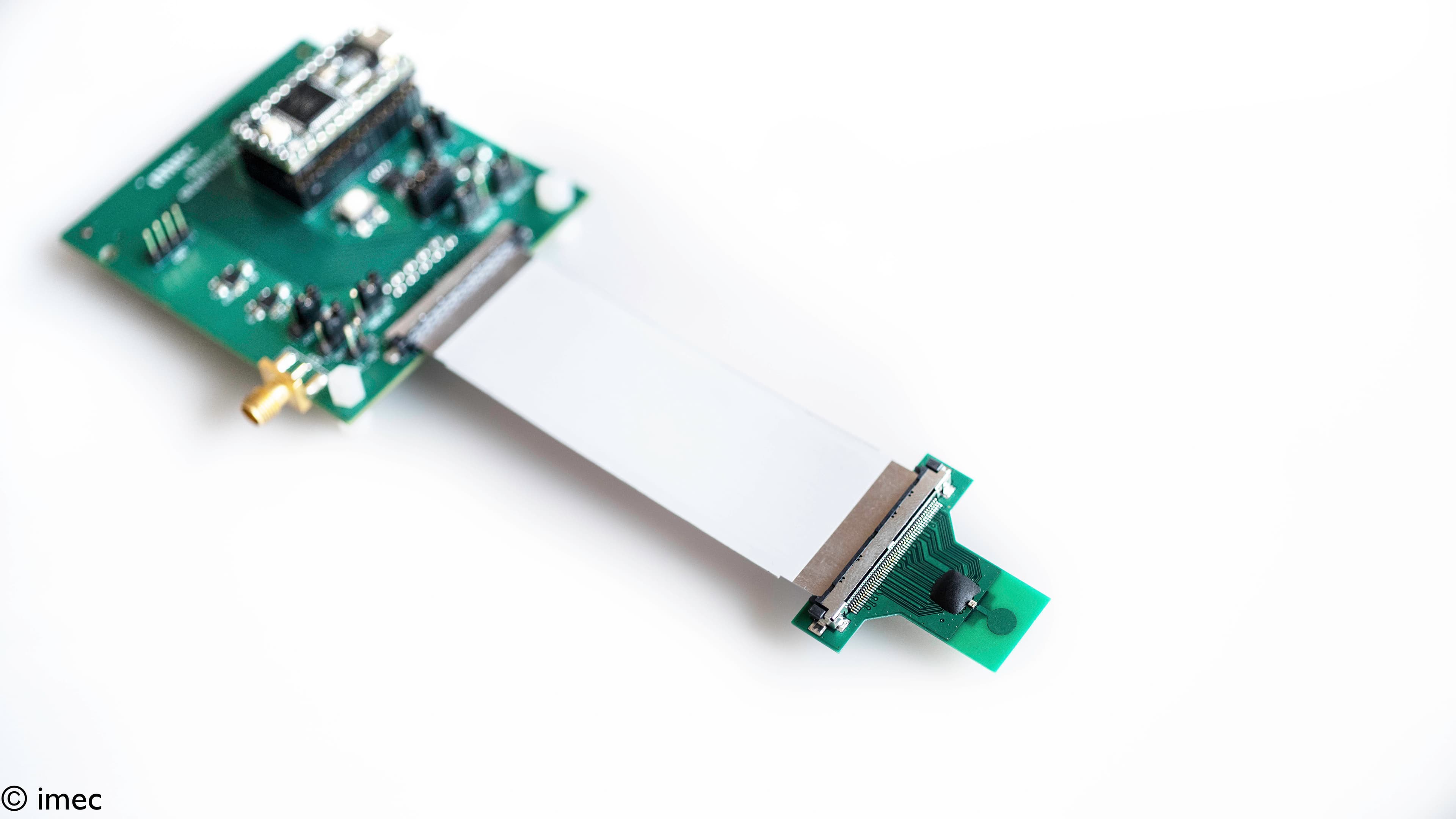 Ultra-wideband transmitter chip on circuit board Ultra-wideband transmitter chip connected to a small circuit board on a white background