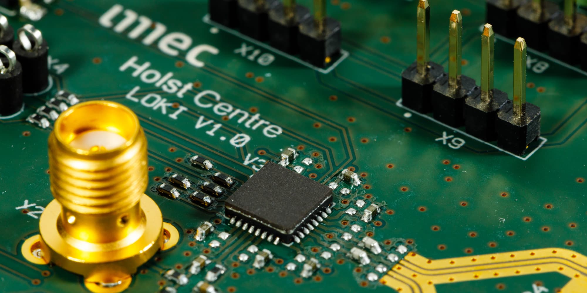 uwb-2021 Close-up of an imec Holst Centre Lokia V1.0 circuit board with a chip, connectors, and a gold antenna port