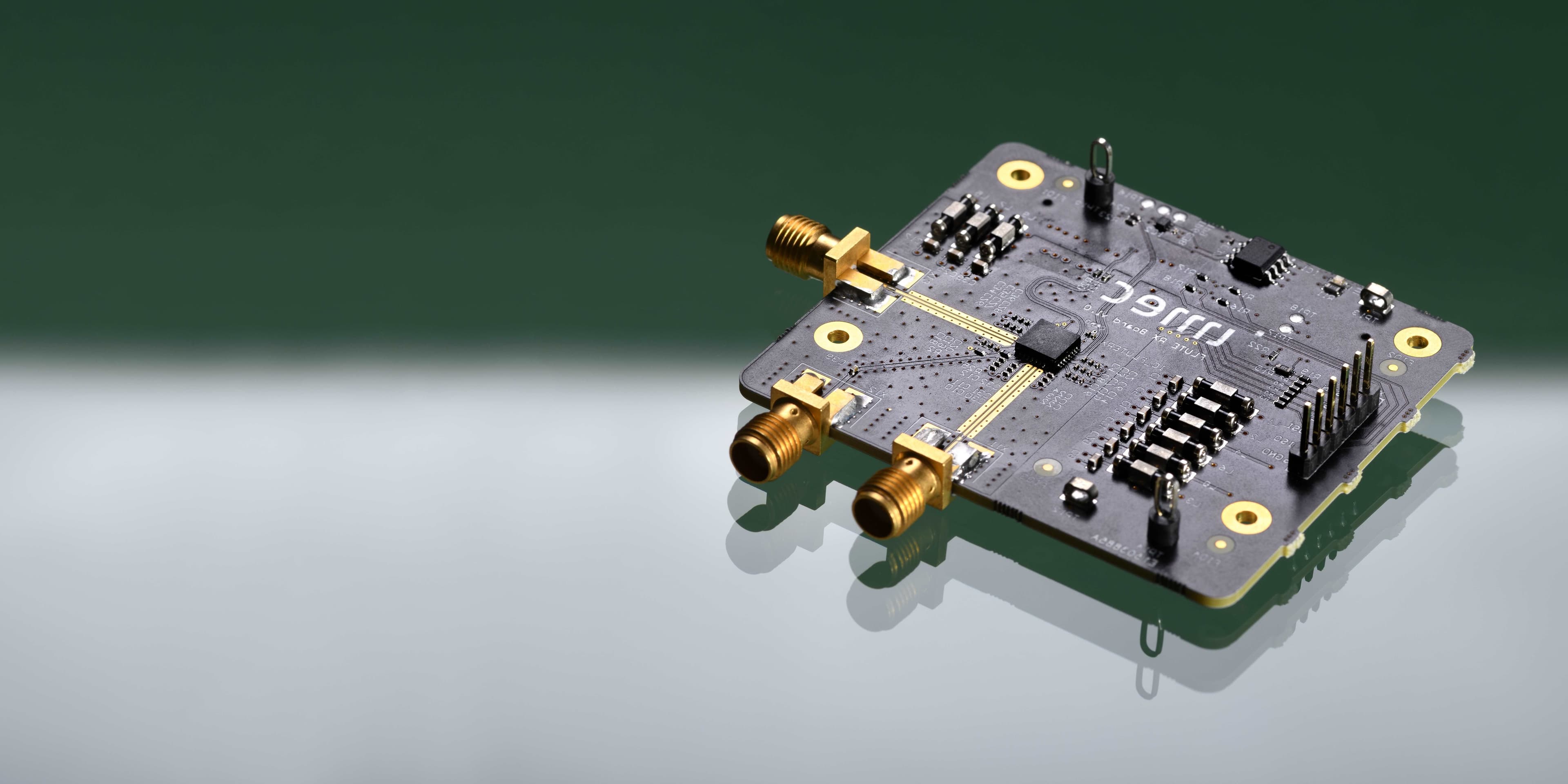 UWB_header UWB receiver circuit board with gold connectors and chip components on a reflective surface