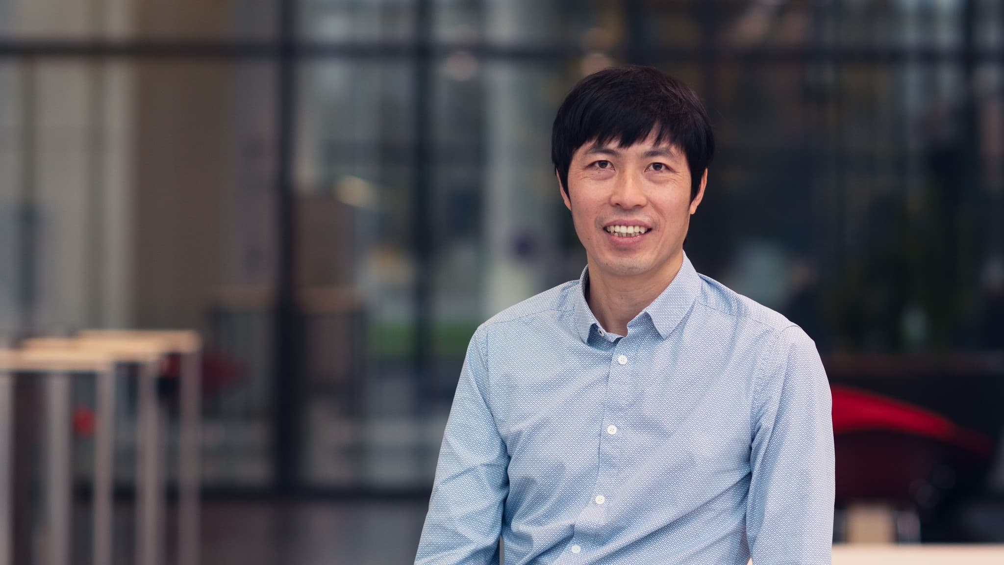 Van%20Dai%20Nguyen Van Dai Nguyen, senior researcher for magnetic devices at imec, standing in front of a blurred lab background