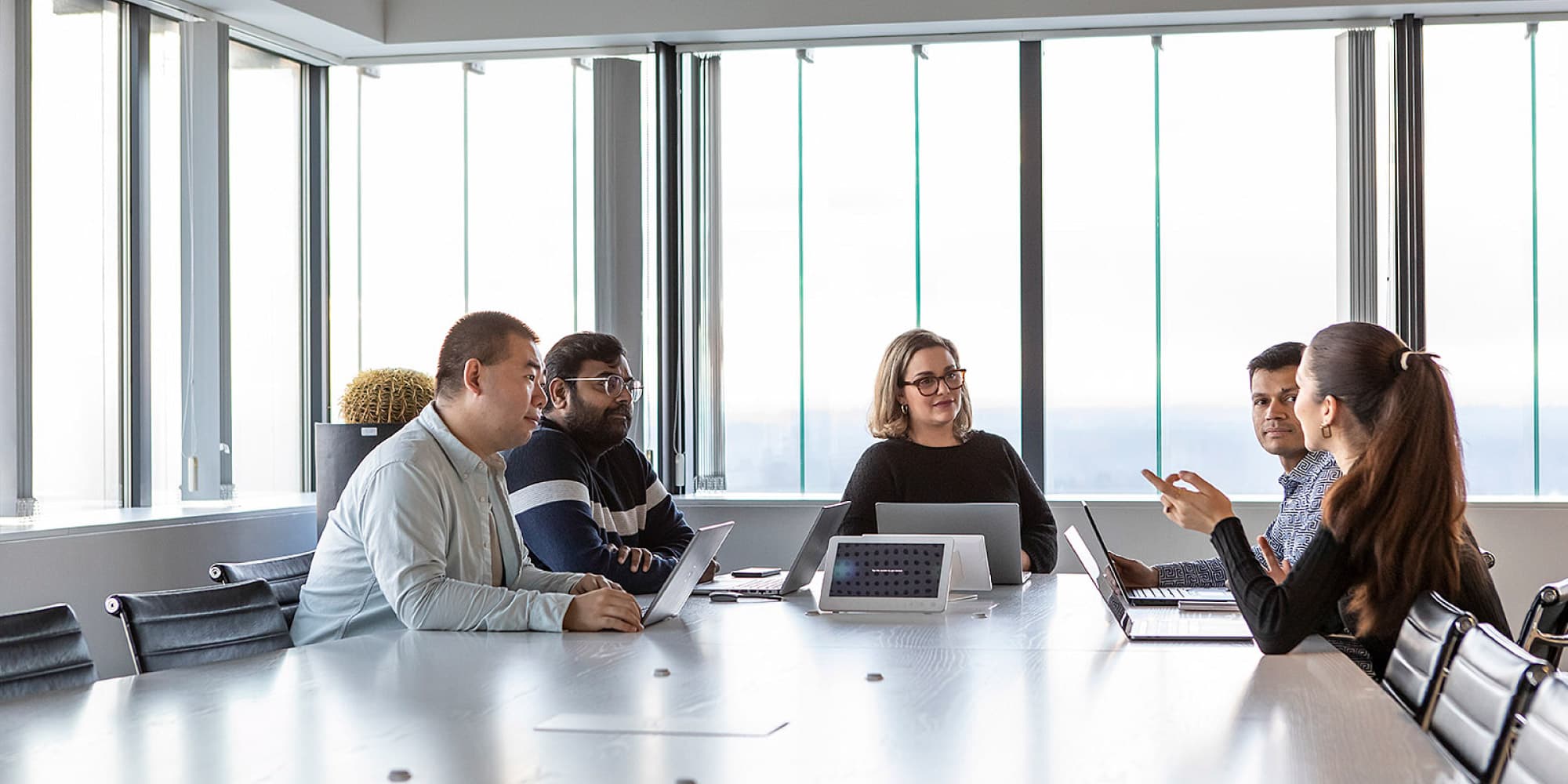 Venturing A diverse team meeting around laptops in a bright conference room