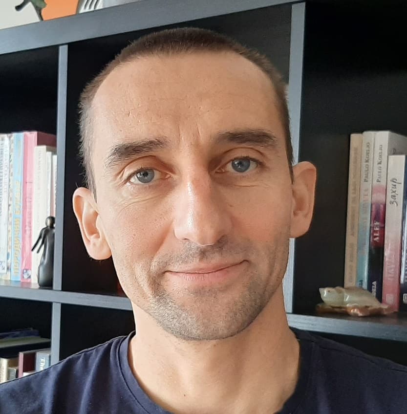 Vojkan Portrait of Vojkan Mihajlović, senior researcher at imec, in front of a bookshelf