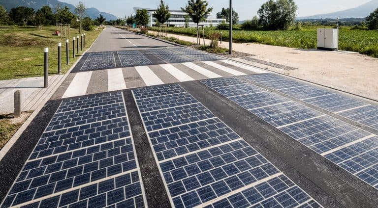 Solar panel test embedded in road with crosswalk Solar panel test sections embedded in a road surface at a Wattway site, with a crosswalk and open landscape beyond.
