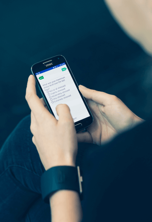 wearable_band_0 Person using a smartphone stress questionnaire while wearing a wristband sensor