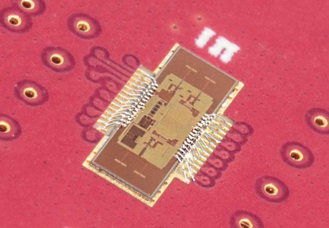 Wisens-PCB002-crop_1 Microchip mounted on a red circuit board with gold contact points